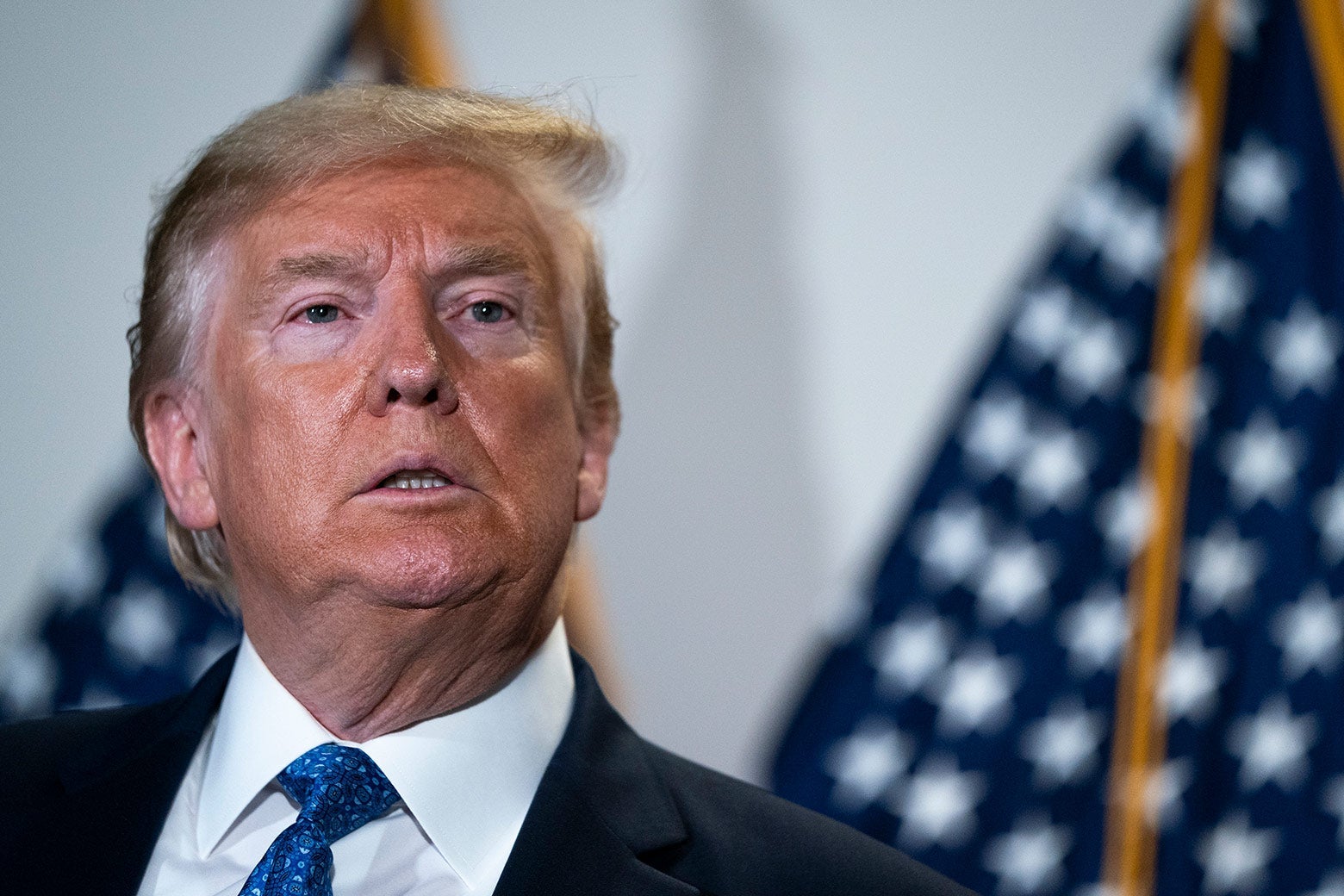 Donald Trump in front of American flags. 