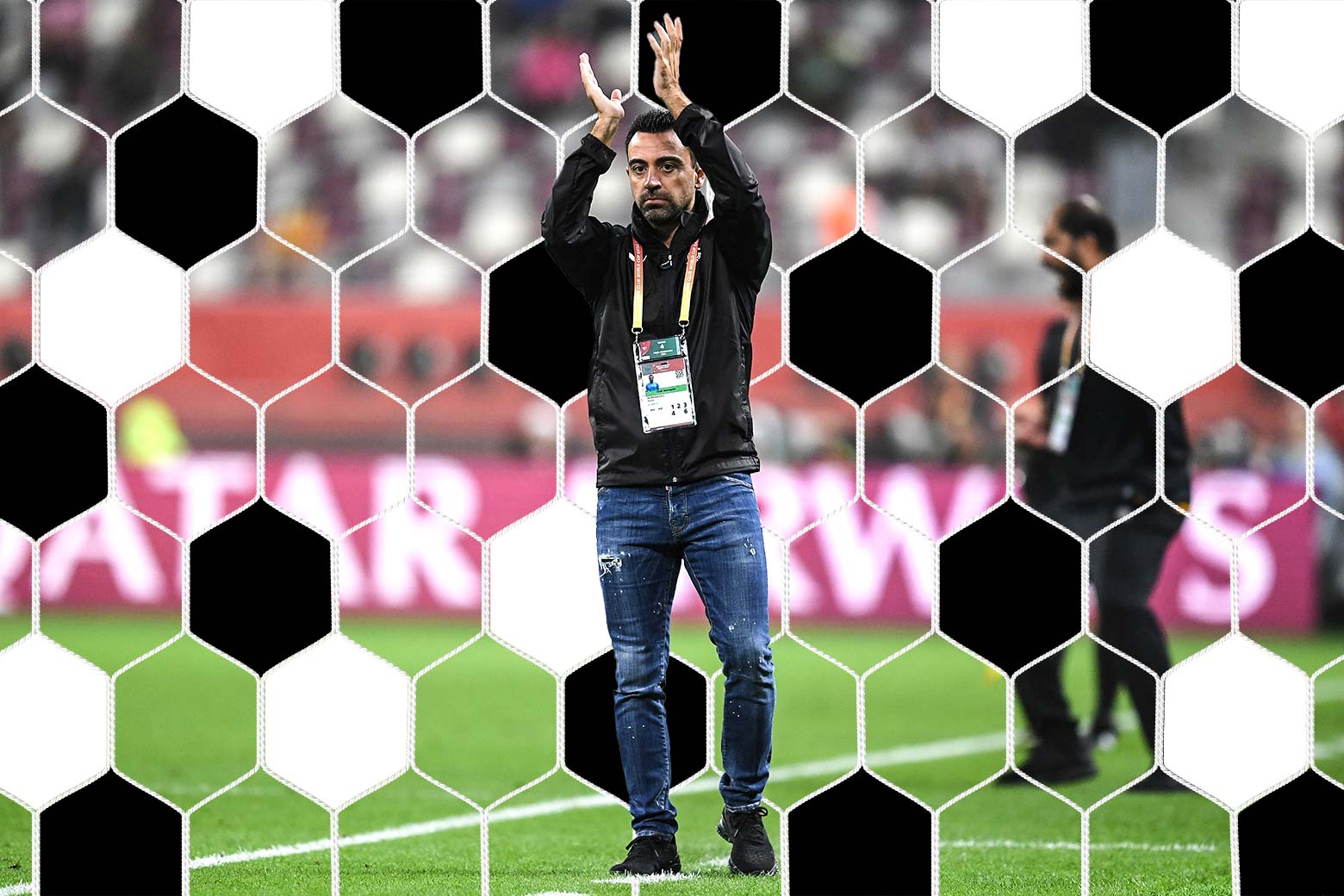 Xavi raises his arms and claps on the field with a big Qatar Airways logo behind him, a net scrim illustrated behind him.