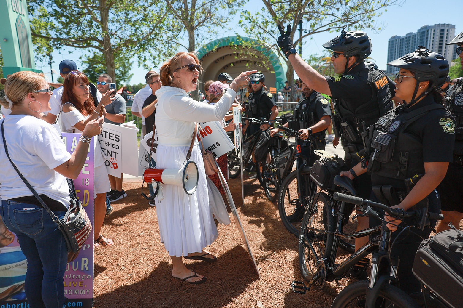 A woman in white yells at police at an anti-abortion rally.