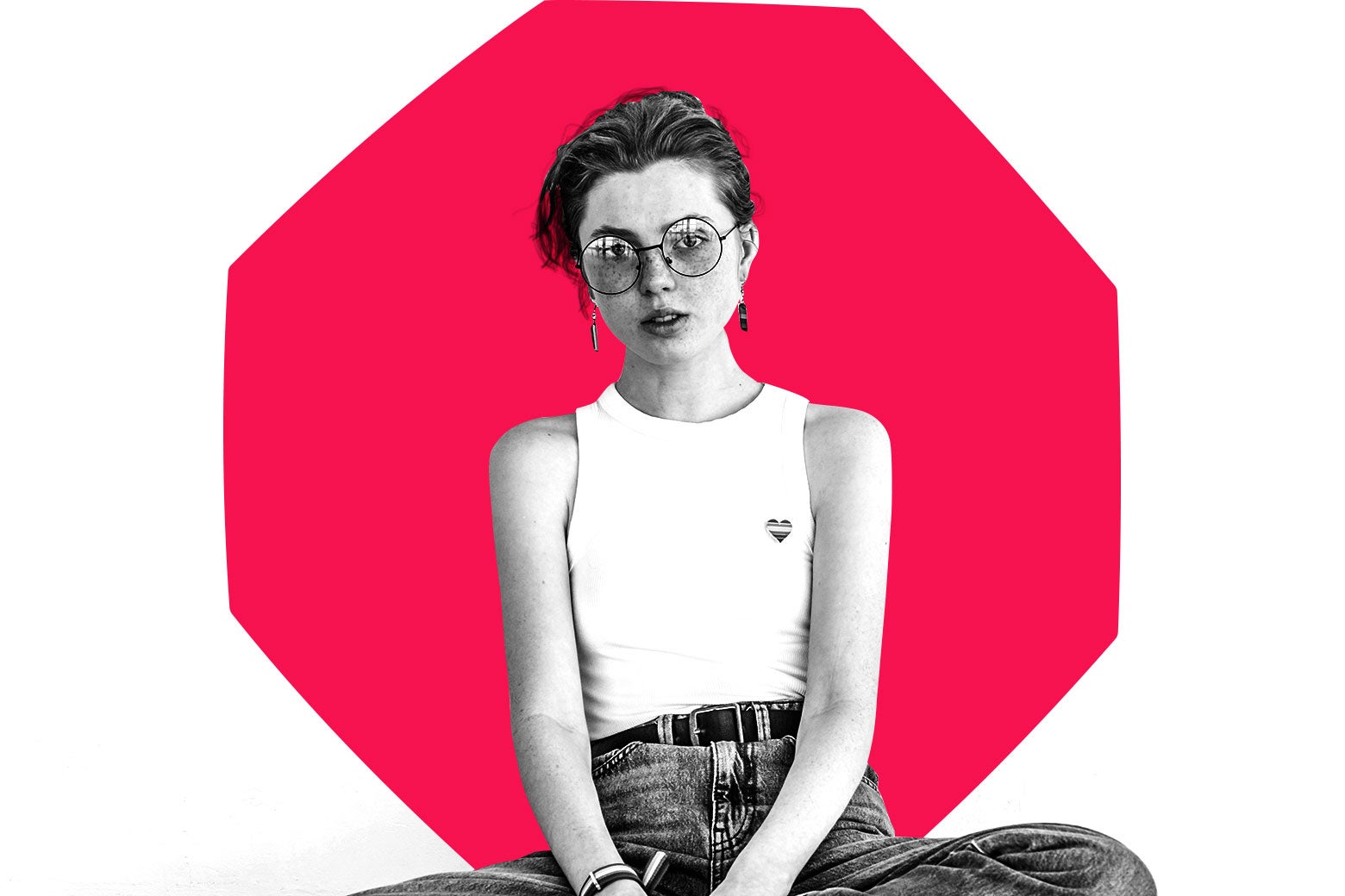 Girl with a short haircut and white tee sitting cross-legged. There's a stop sign overlaid behind her.