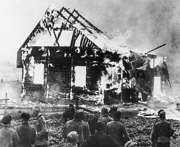Nazi officers and Lithuanian locals look on as a synagogue burns