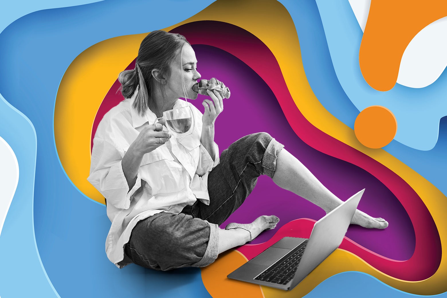 A woman eating a croissant and using her laptop on the floor.