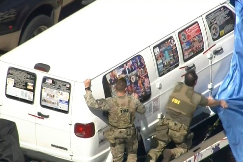 FBI agents attempt to cover the alleged mail bomber’s van.