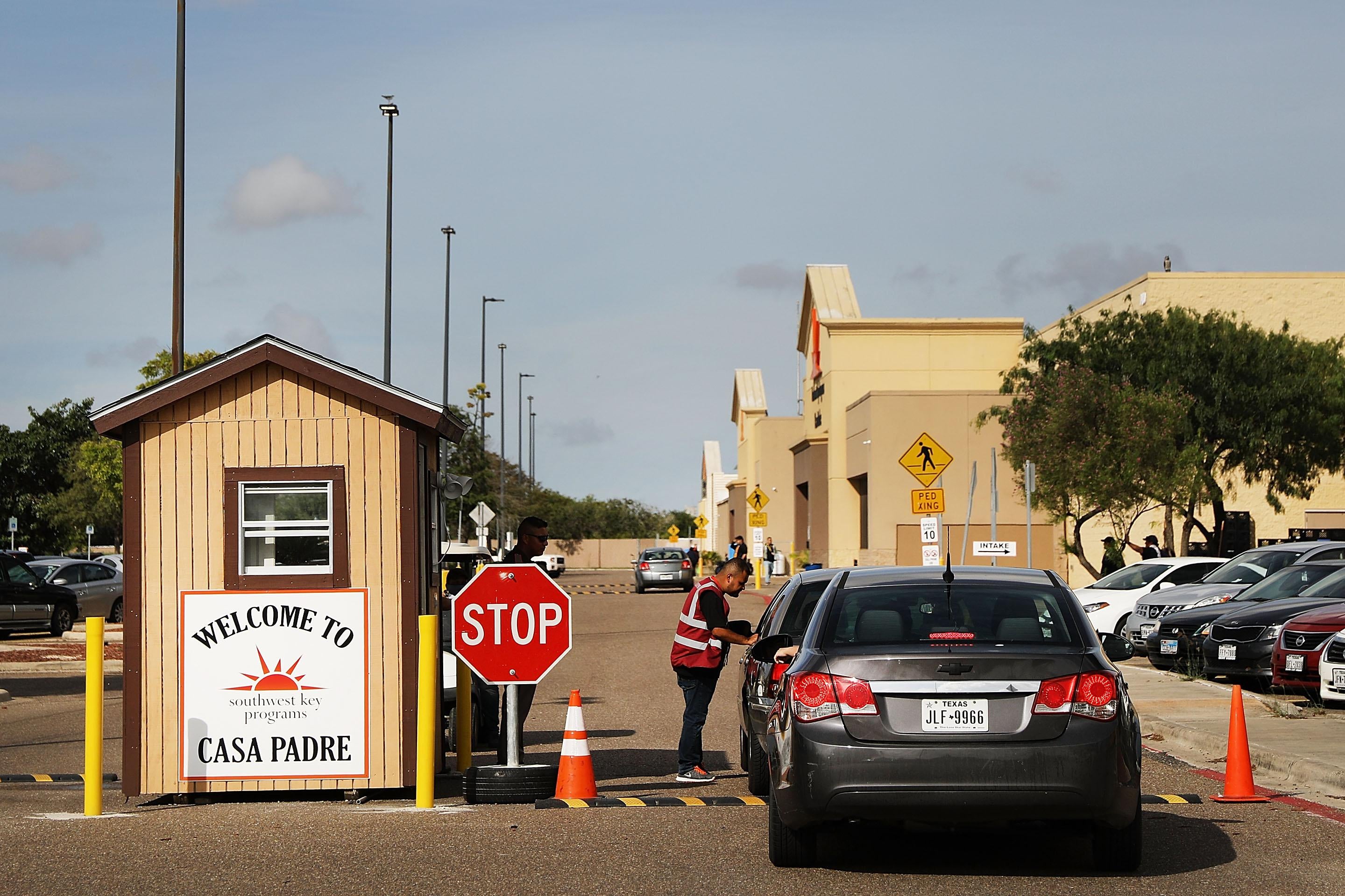 A security guard checks cars at the entrance to Casa Padre, a former Walmart which is now a center for unaccompanied immigrant children in Brownsville, Texas.