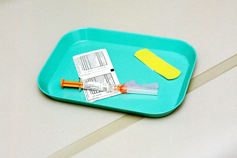 A plastic tray with a syringe, packaged alcohol wipe, and bandage on it.