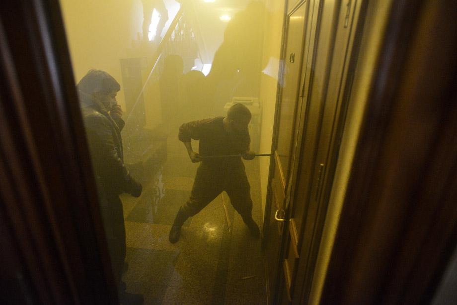 Protesters attempt to break a door inside an office of the pro-presidential Party of the Regions in Kiev on Feb. 18, 2014. UKRAINE/