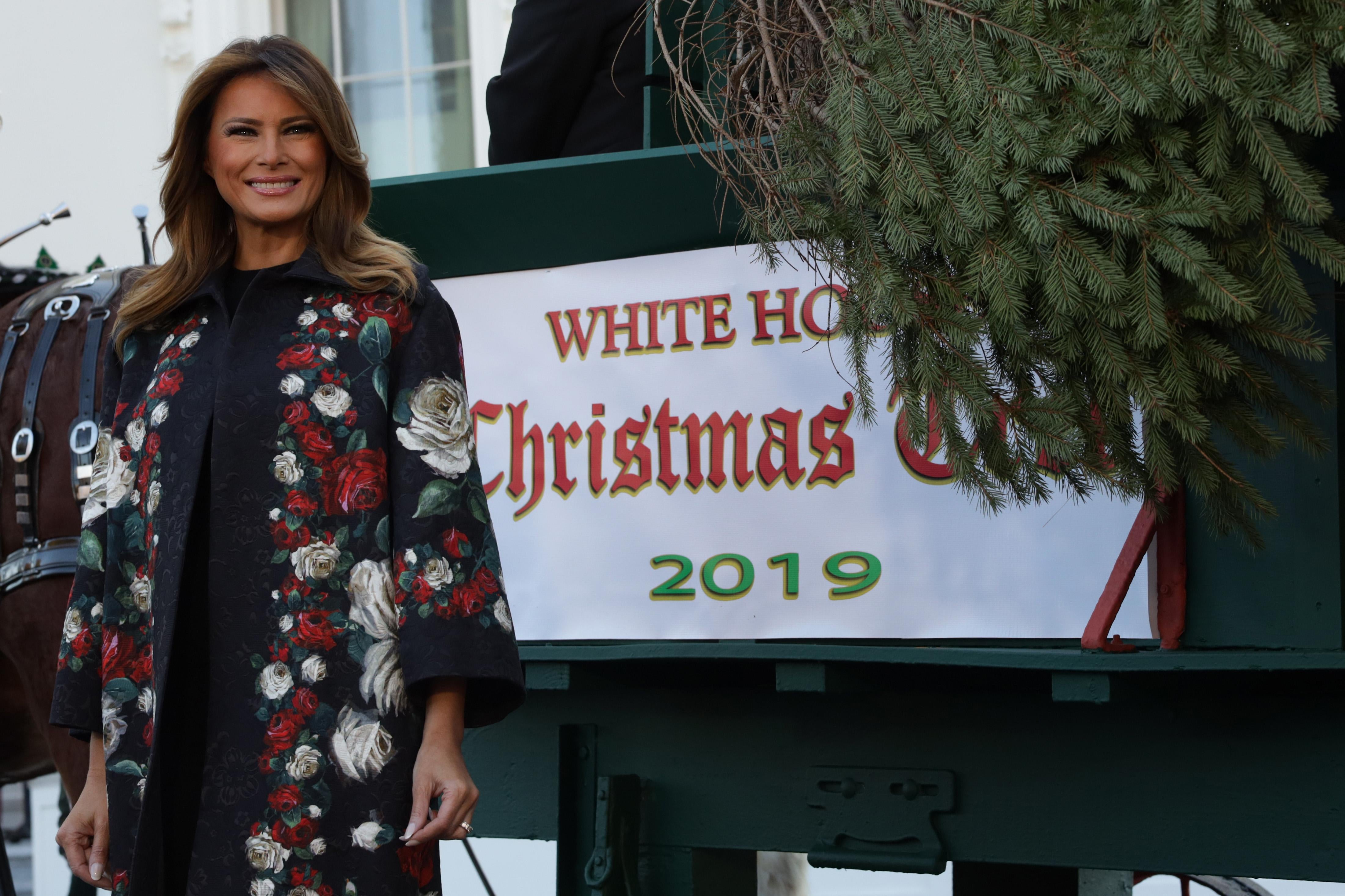 Melania Trump smiles as she receives the 2019 White House Christmas tree outside the White House.