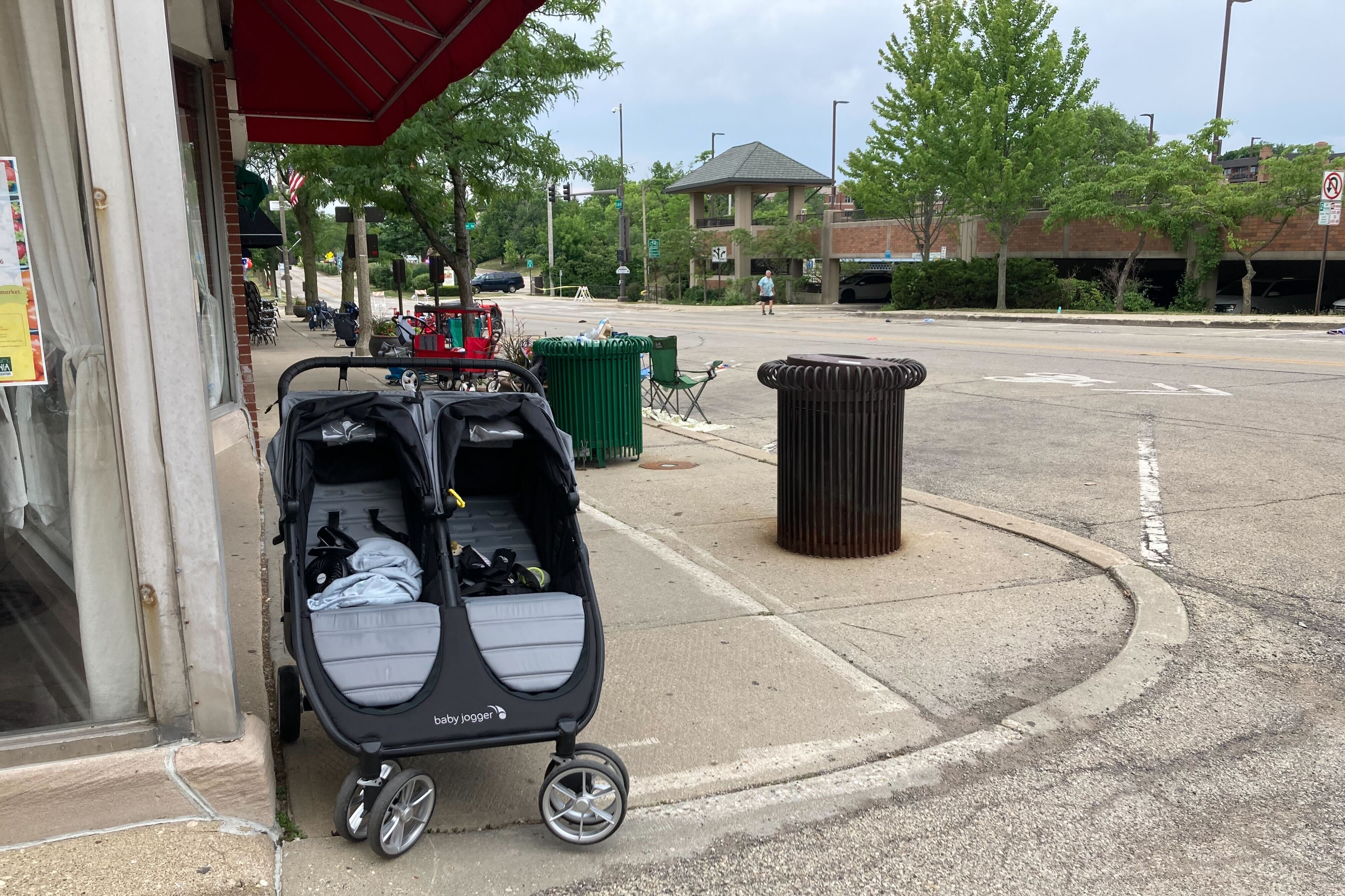 A double stroller sitting at an empty corner.