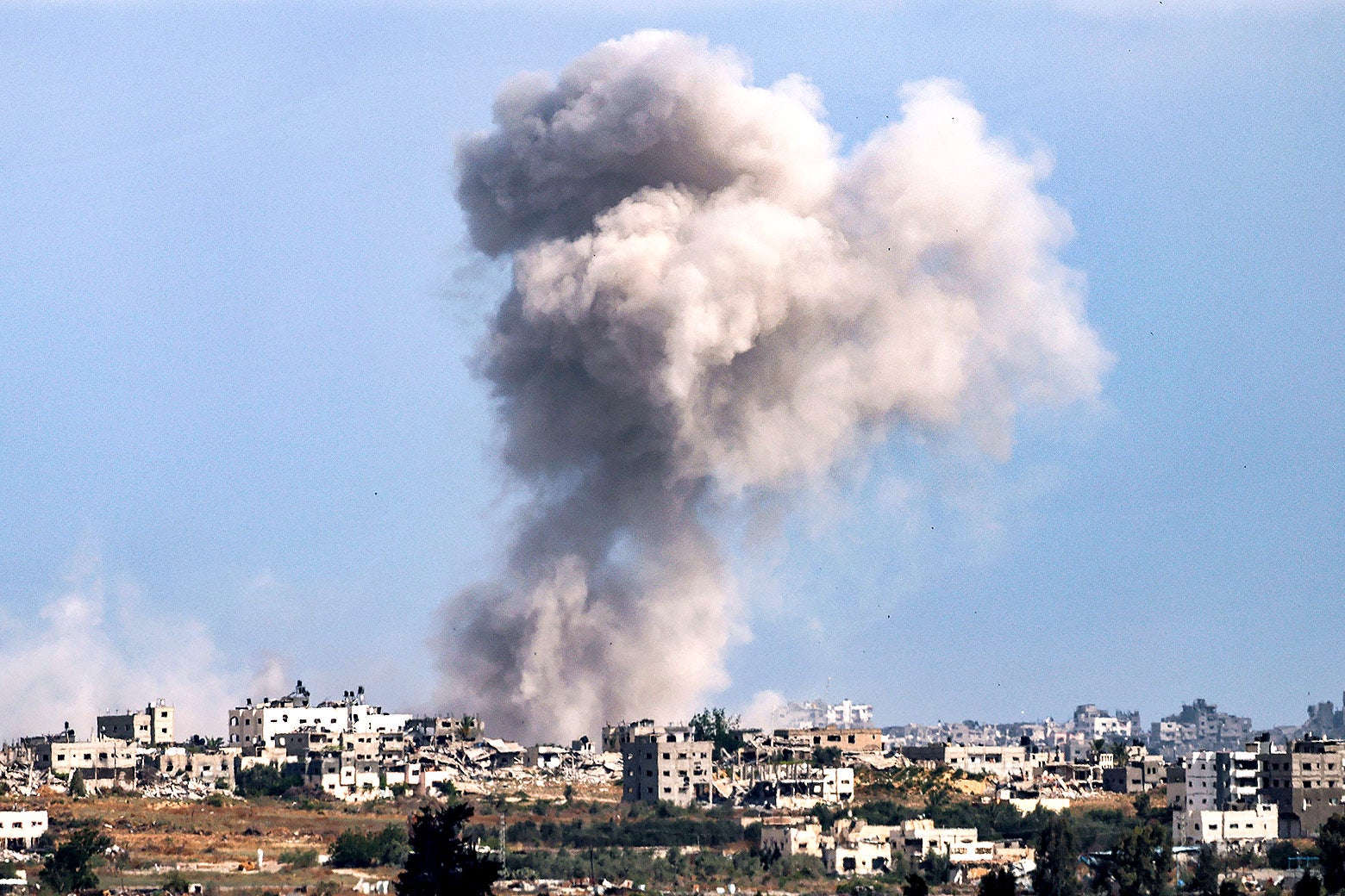 A smoke plume from an explosion billows in the Gaza Strip as seen from a position along Israel's southern border.