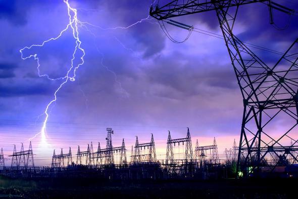 Power distribution station with lightning striking electricity towers.
