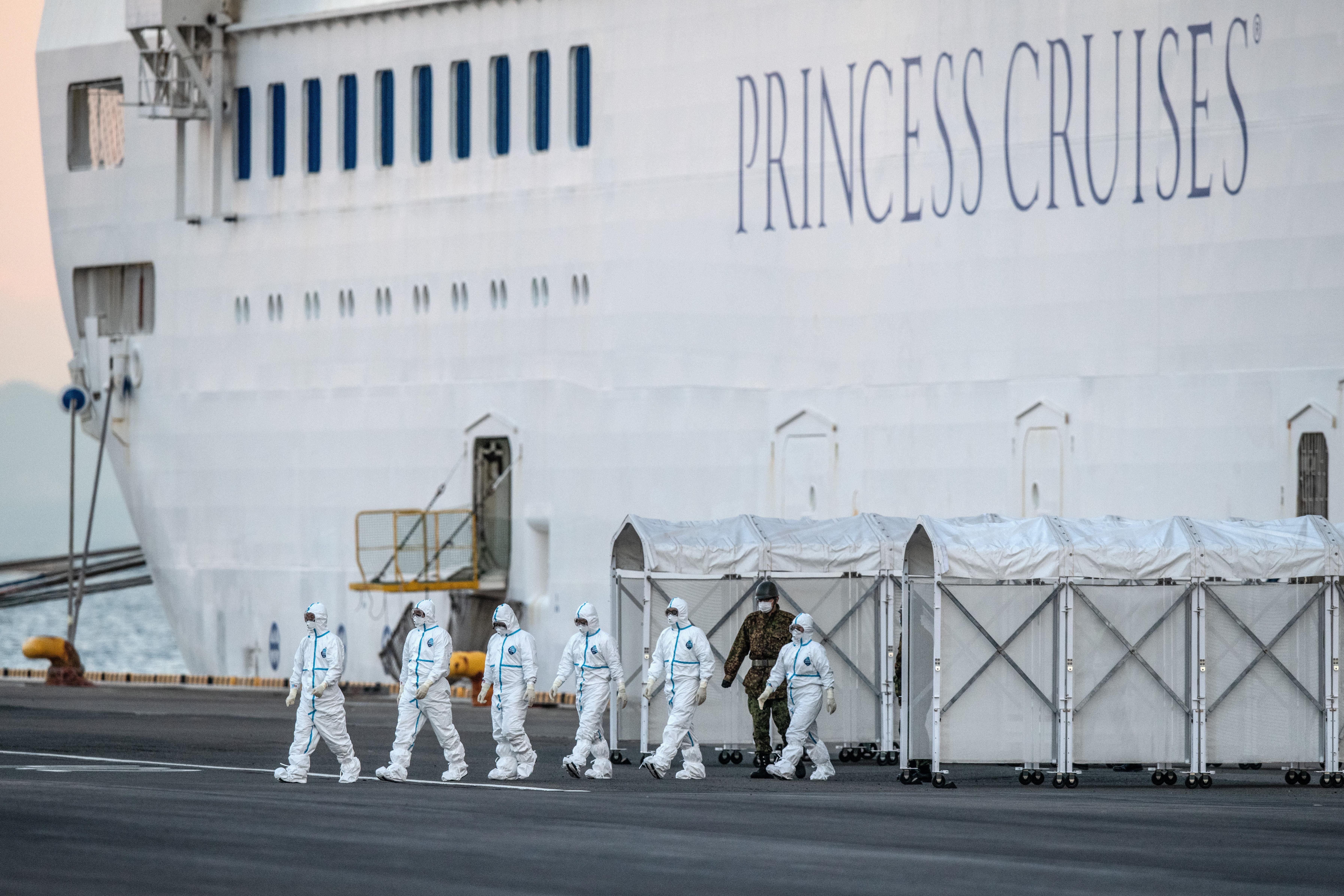 Emergency workers in protective clothing exit the Diamond Princess cruise ship on Feb. 10, 2020.