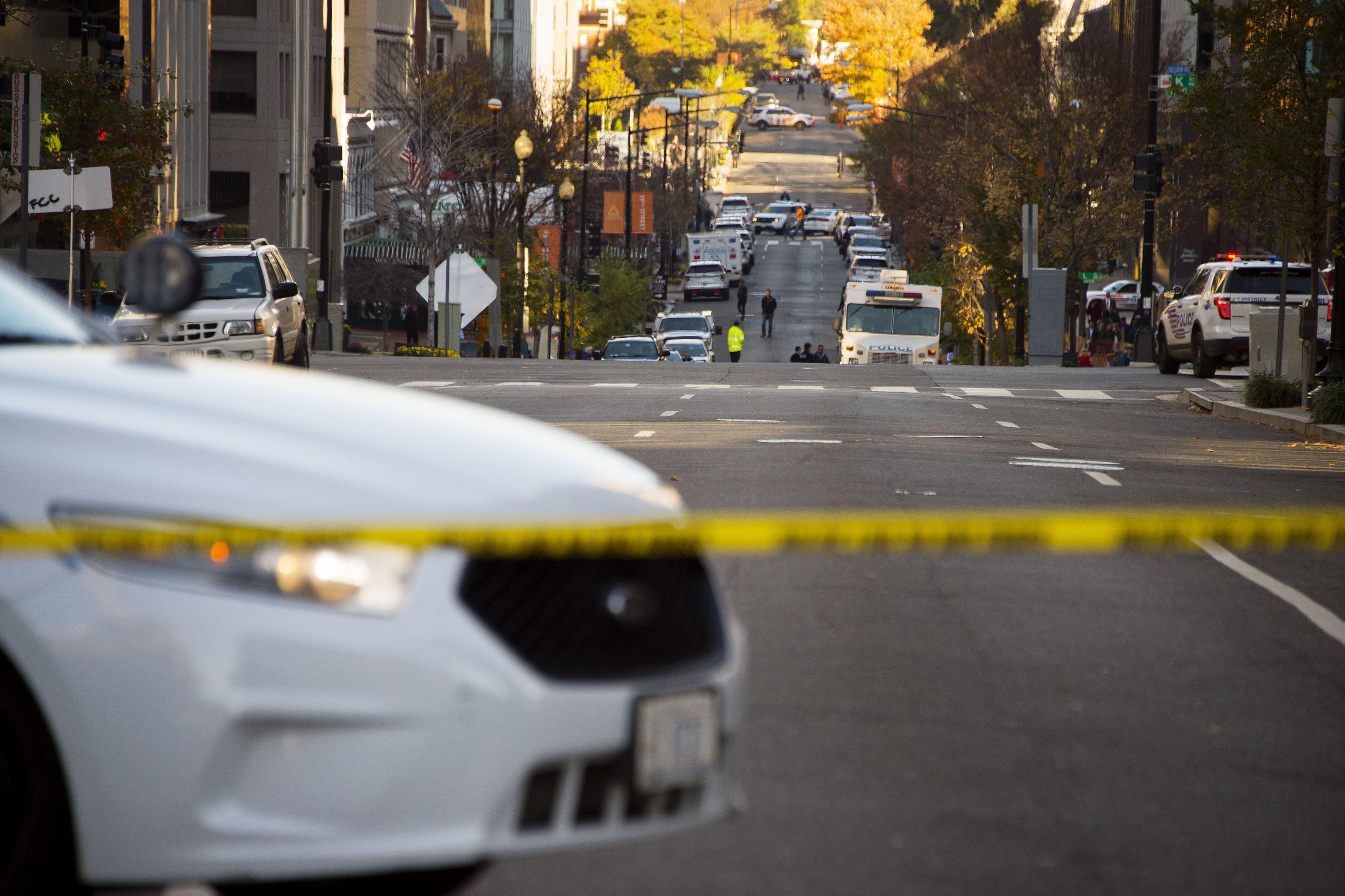 Police cars line 19th Street NW in Washington, DC, November 16, 2015, during a barricade situation. The Washington post reported that police said a woman fired a shot in the area around midnight and it turned into a barricade situation inside an office building. No one was injured but situation caused a major traffic snarl during the morning rush hour in downtown DC.  AFP PHOTO / JIM WATSON        (Photo credit should read JIM WATSON/AFP/Getty Images)