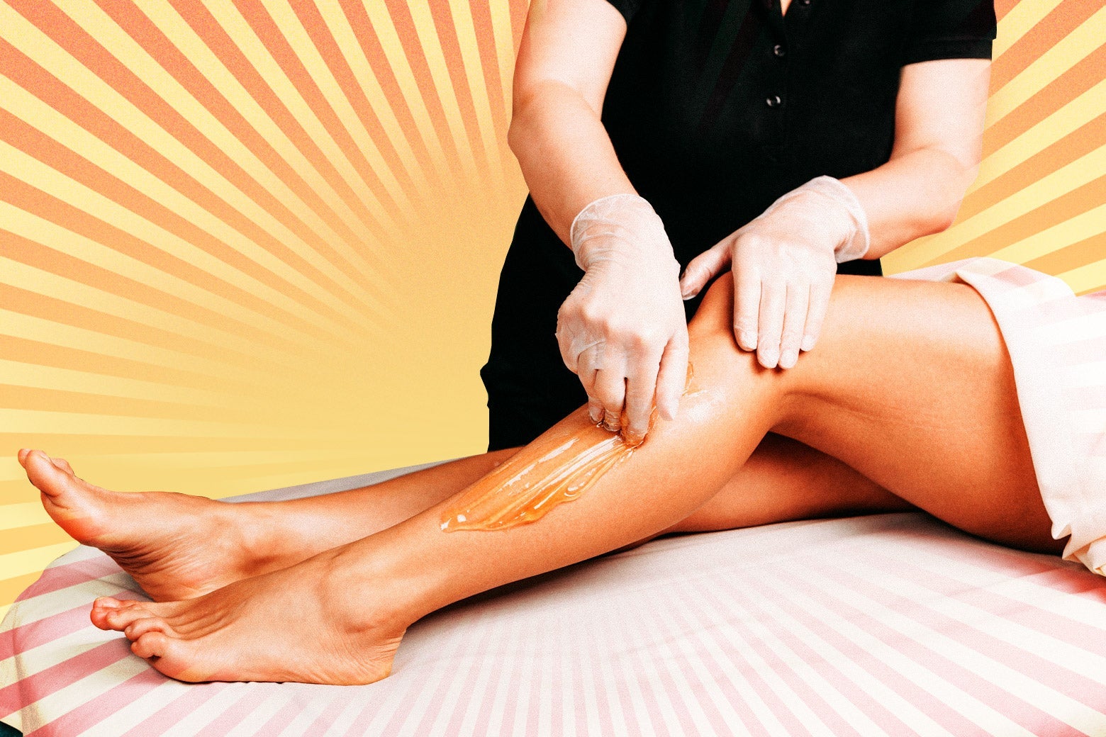 A pair of legs get waxed by a professional.