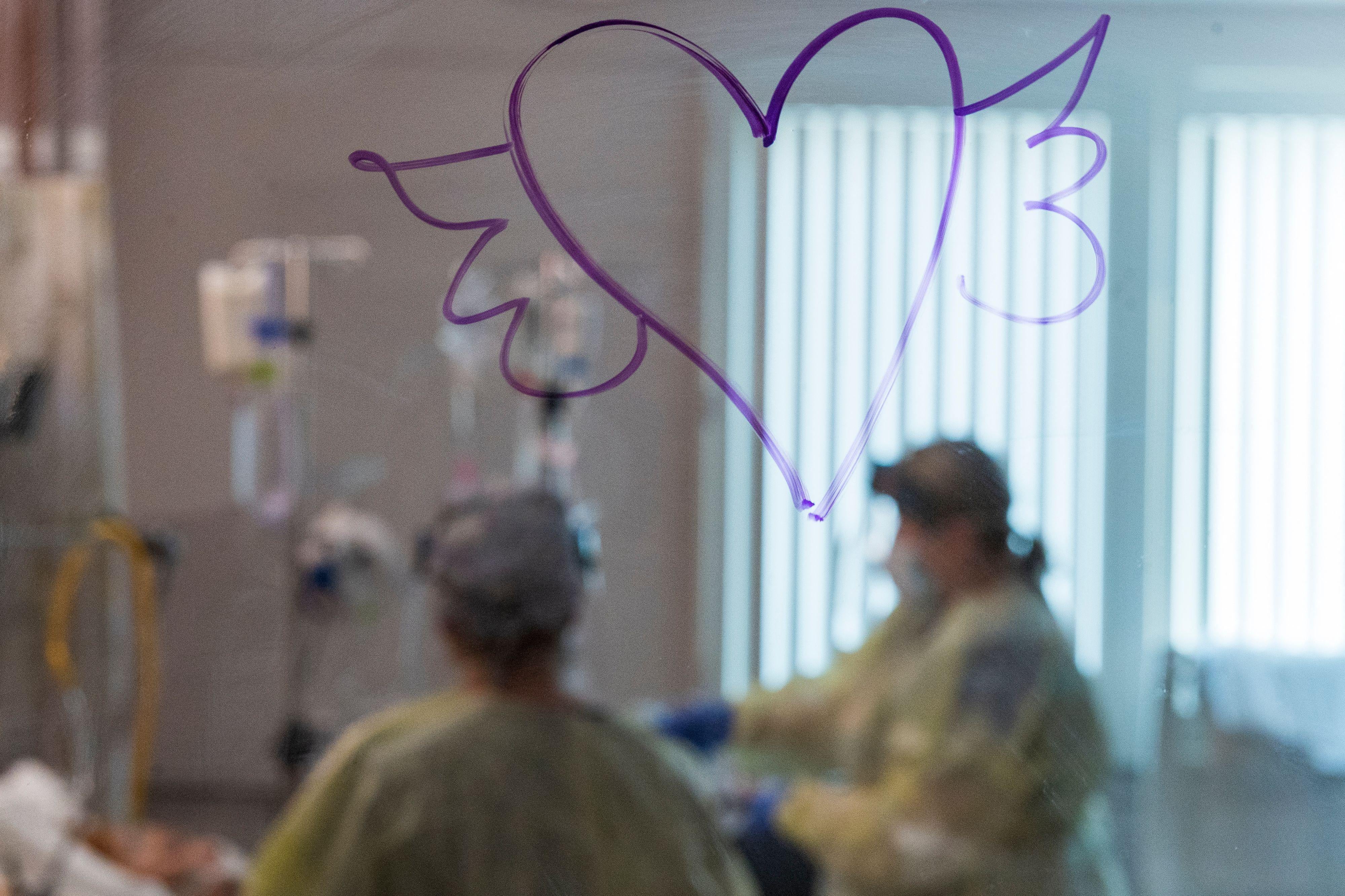A heart with wings is drawn on the window as nurses care for a Covid-19 patient inside the intensive care unit at Adventist Health in Sonora, California on August 27, 2021. 