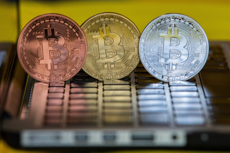 Bitcoins perched on a laptop.