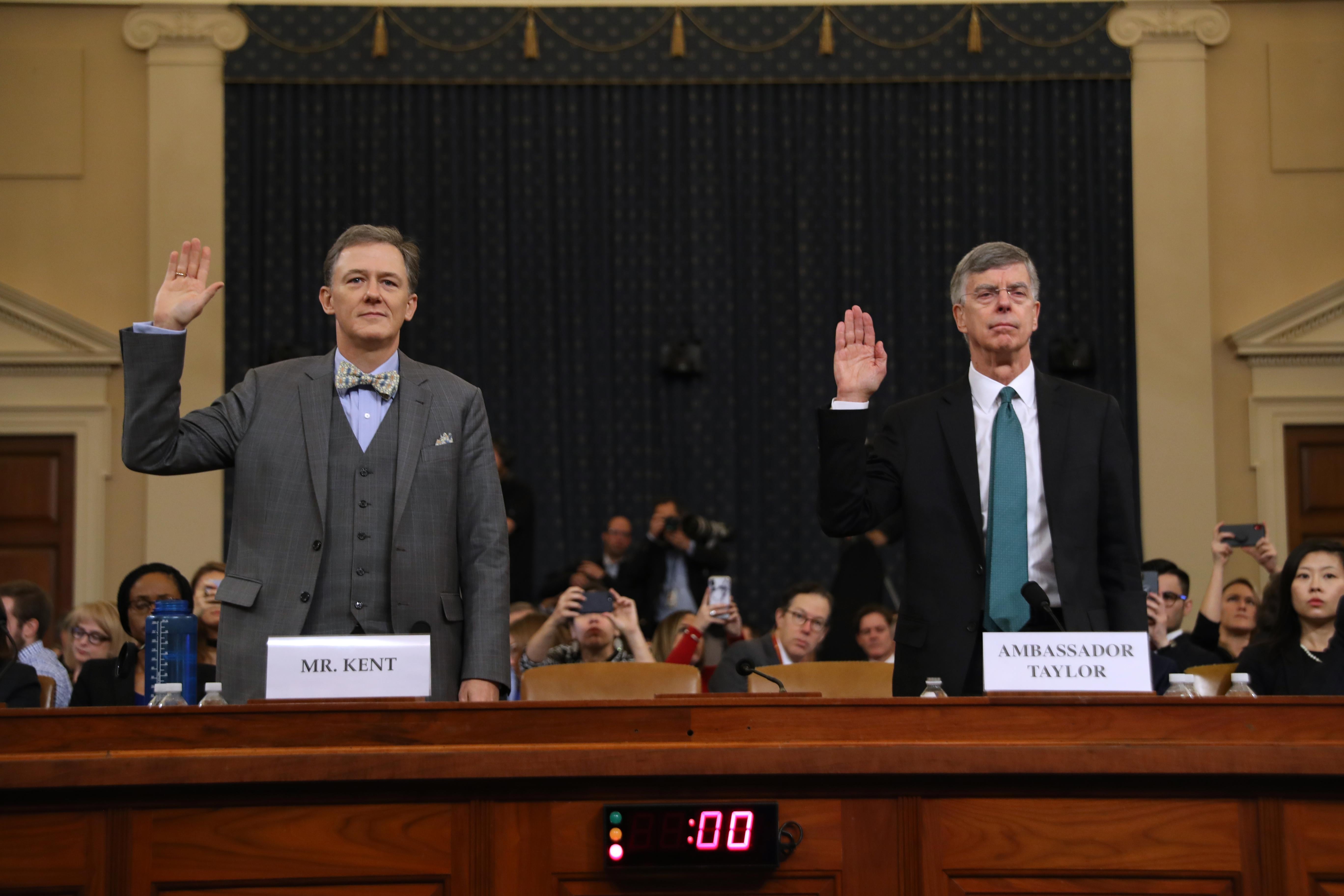 George Kent and Bill Taylor raise their hands as they are sworn in.