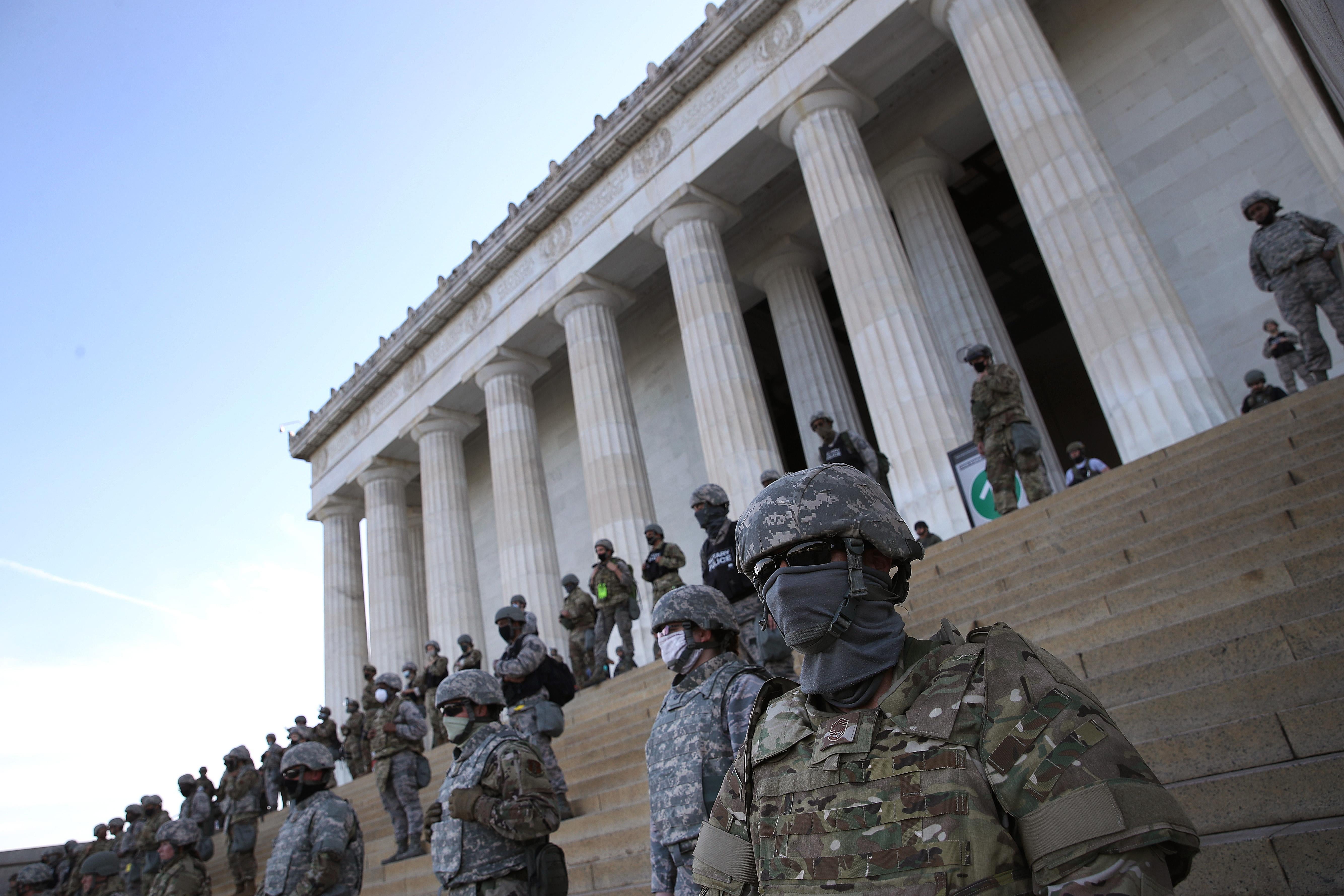 National Guard troops in dark sunglasses on the steps of the Lincoln memorial.