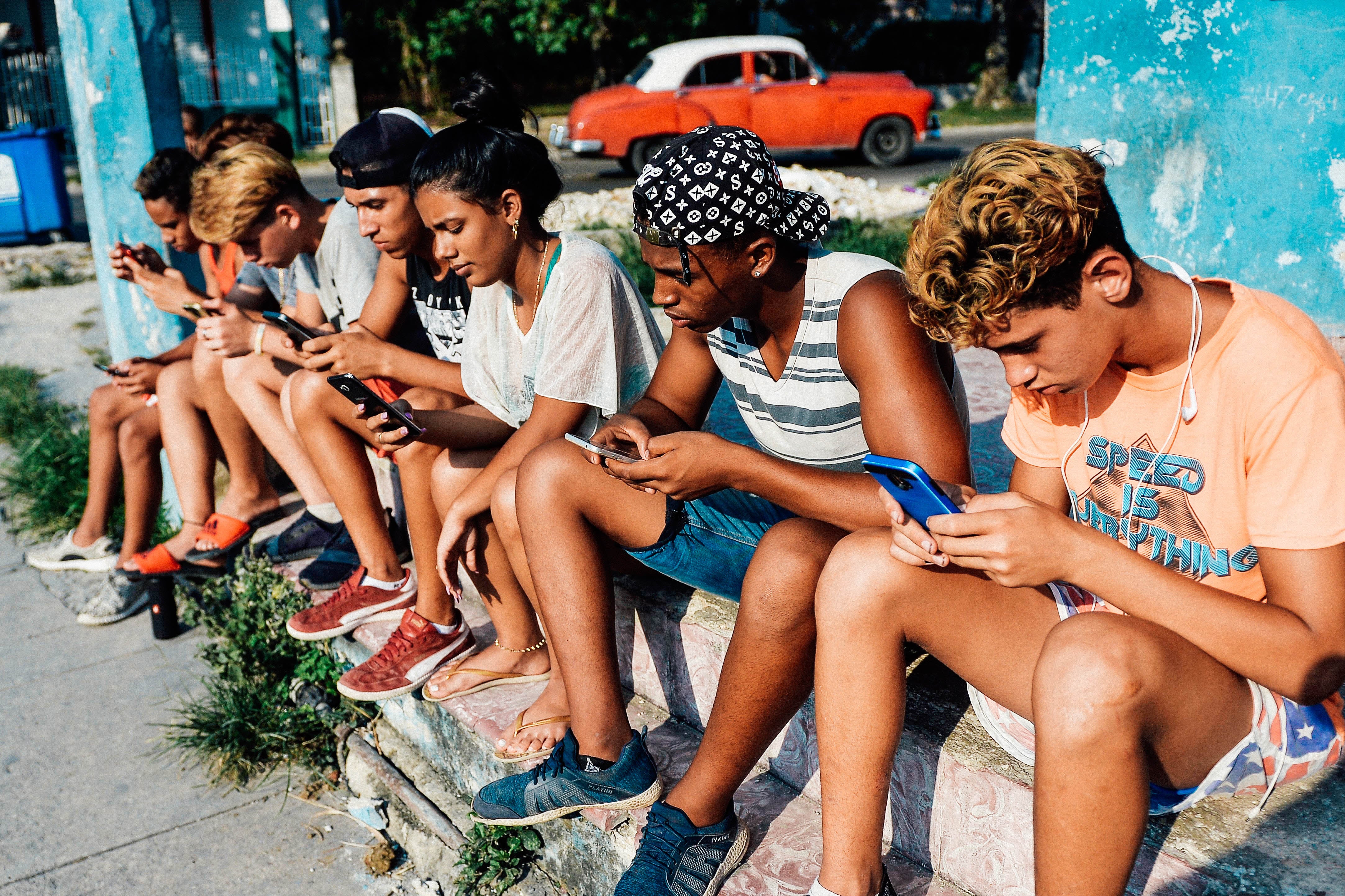 Young Cubans connect to internet from their mobile phones in Havana on June 6.