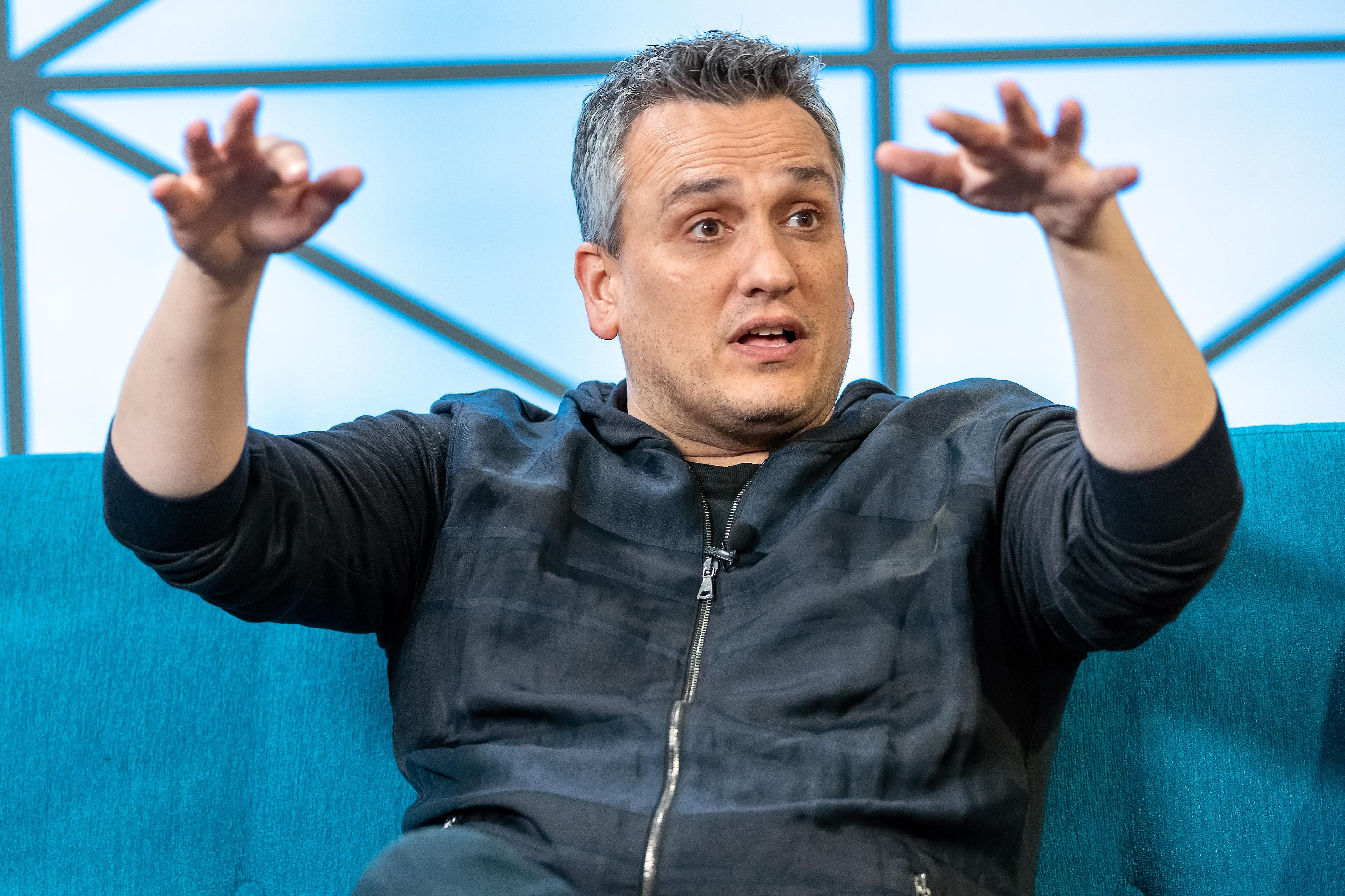 Joe Russo gestures while talking at an event.