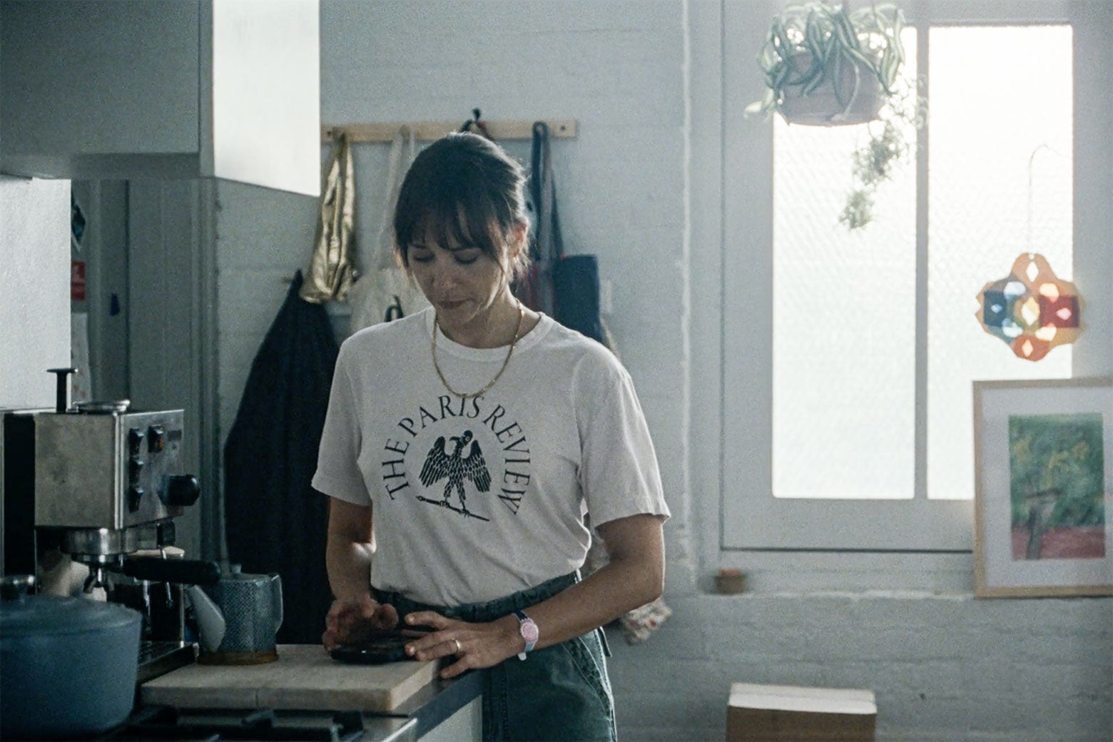 Rashida Jones stands in her light-filled kitchen, wearing a Paris Review T-shirt