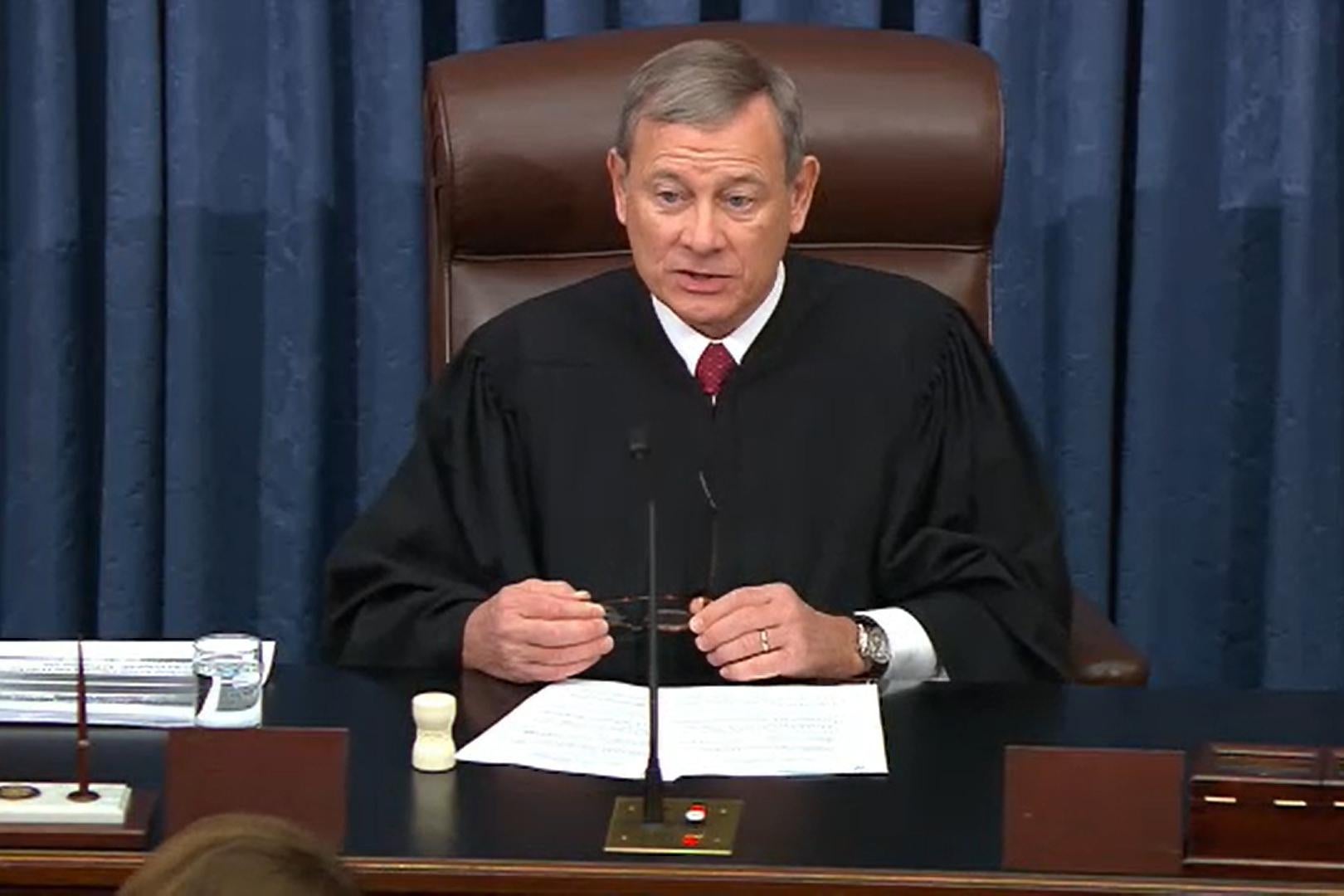 John Roberts in his robes, seated and addressing the Senate.