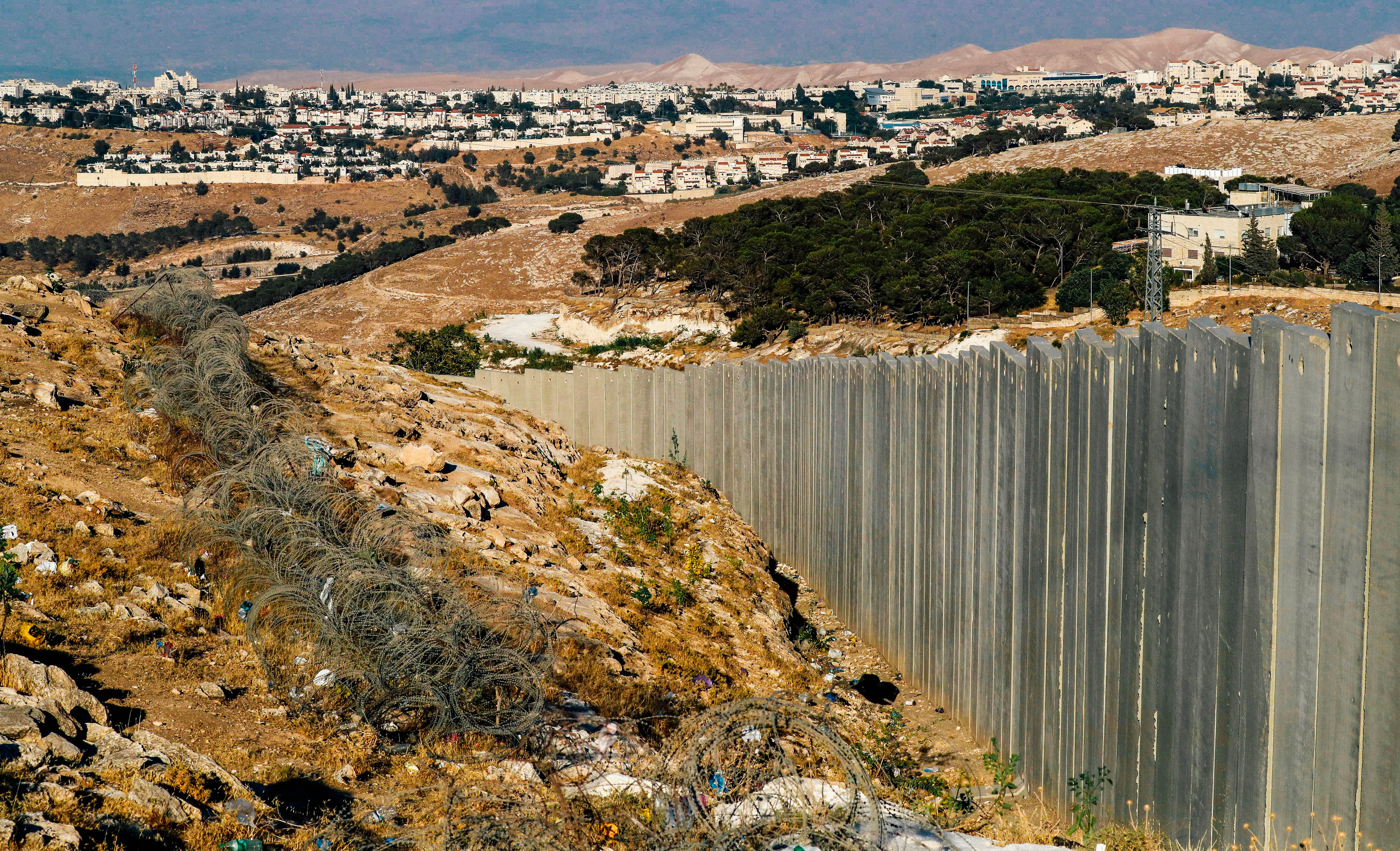 A wall seen in a landscape photo with houses in the background.