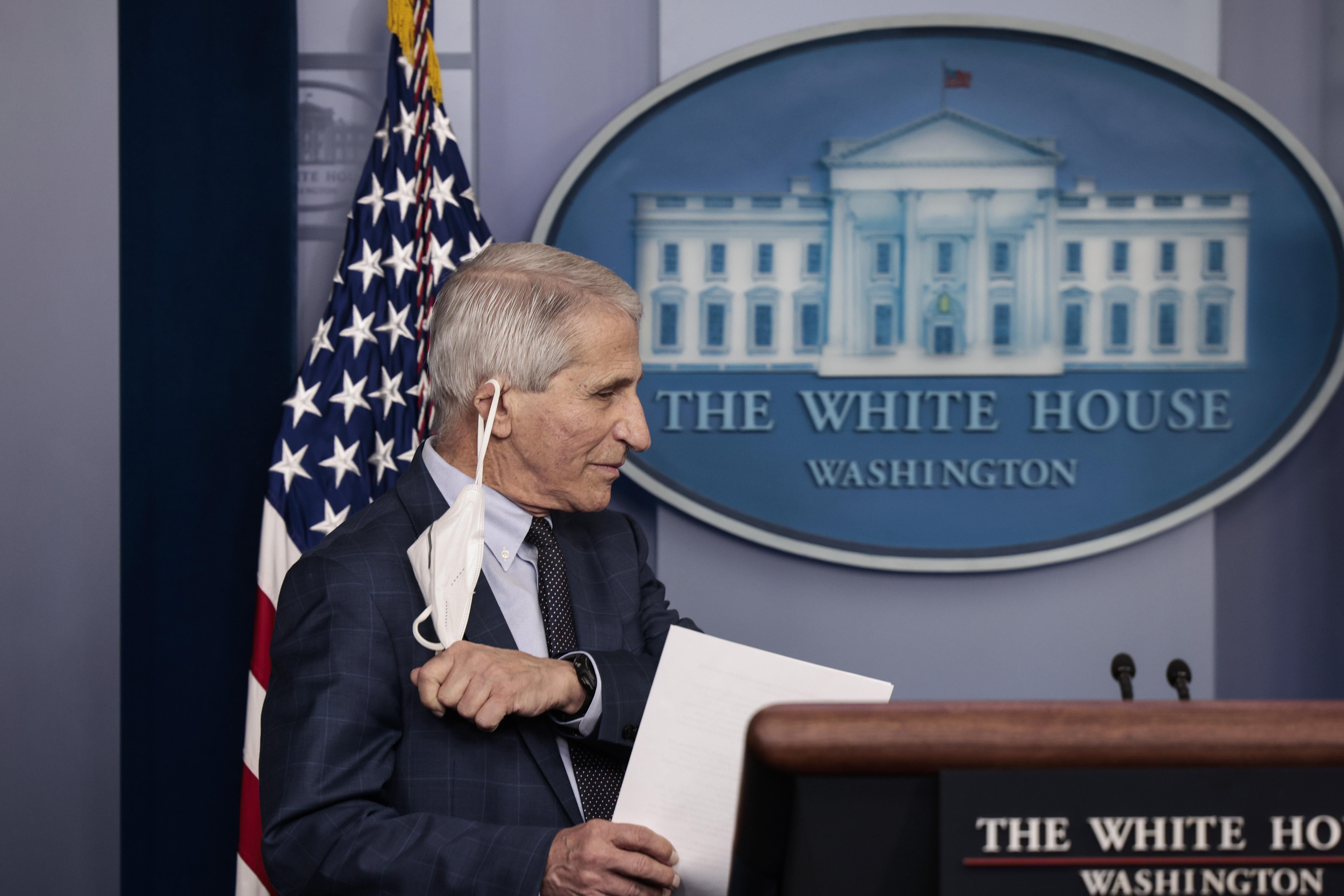 Dr. Anthony Fauci takes his face mask off before giving an update on the omicron COVID-19 variant during the daily press briefing at the White House on December 1, 2021 in Washington, D.C.