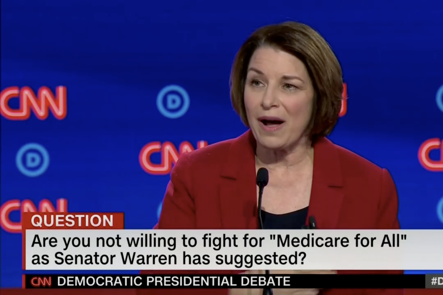 In this screengrab from CNN, Amy Klobuchar debates. The banner reads: “Are you not willing to fight for 'Medicare for All' as Senator Warren has suggested?"
