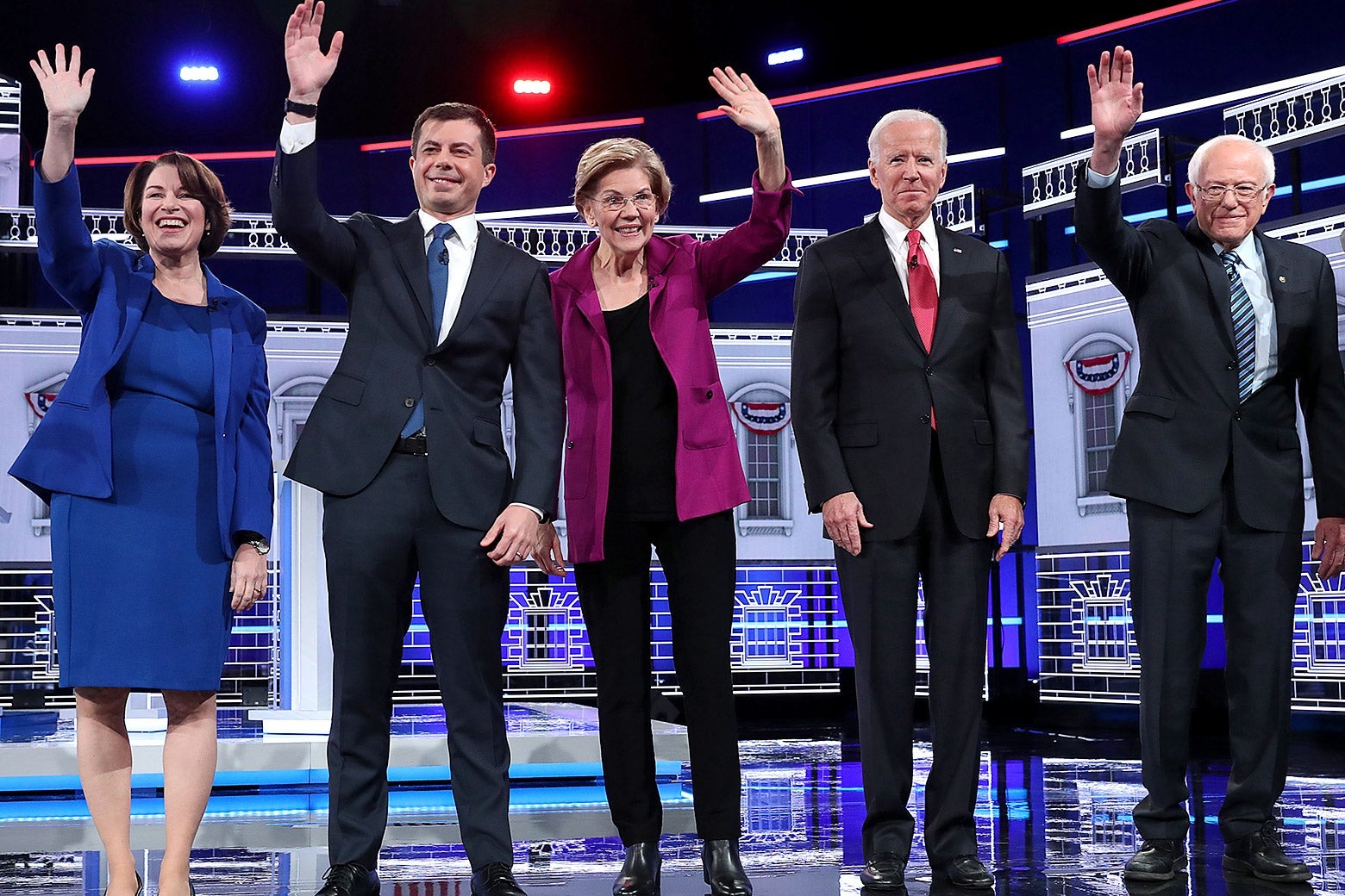 Amy Klobuchar, Pete Buttigieg, Elizabeth Warren, Joe Biden, and Bernie Sanders wave on the debate stage.