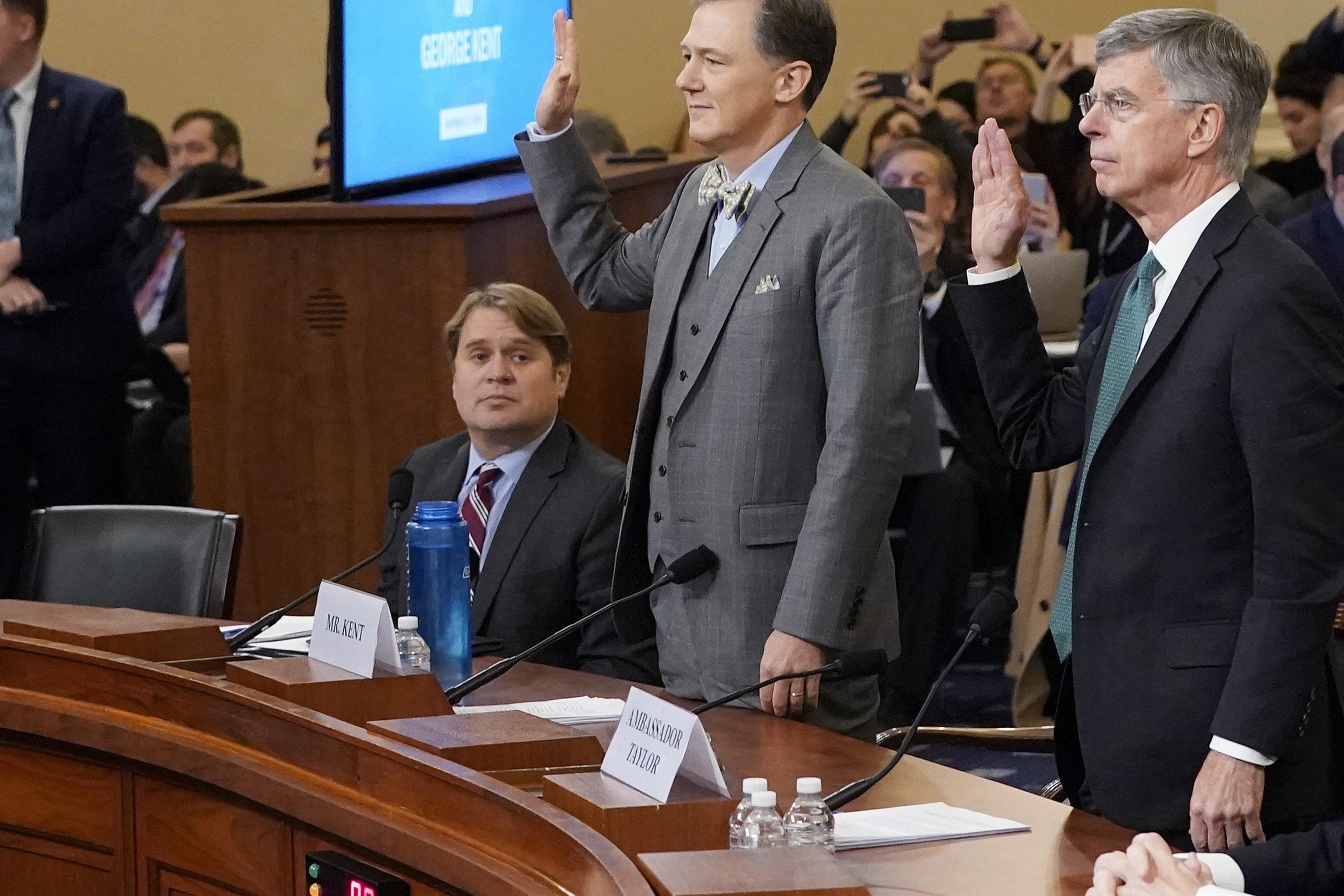Taylor and Kent raise their hands to be sworn in.