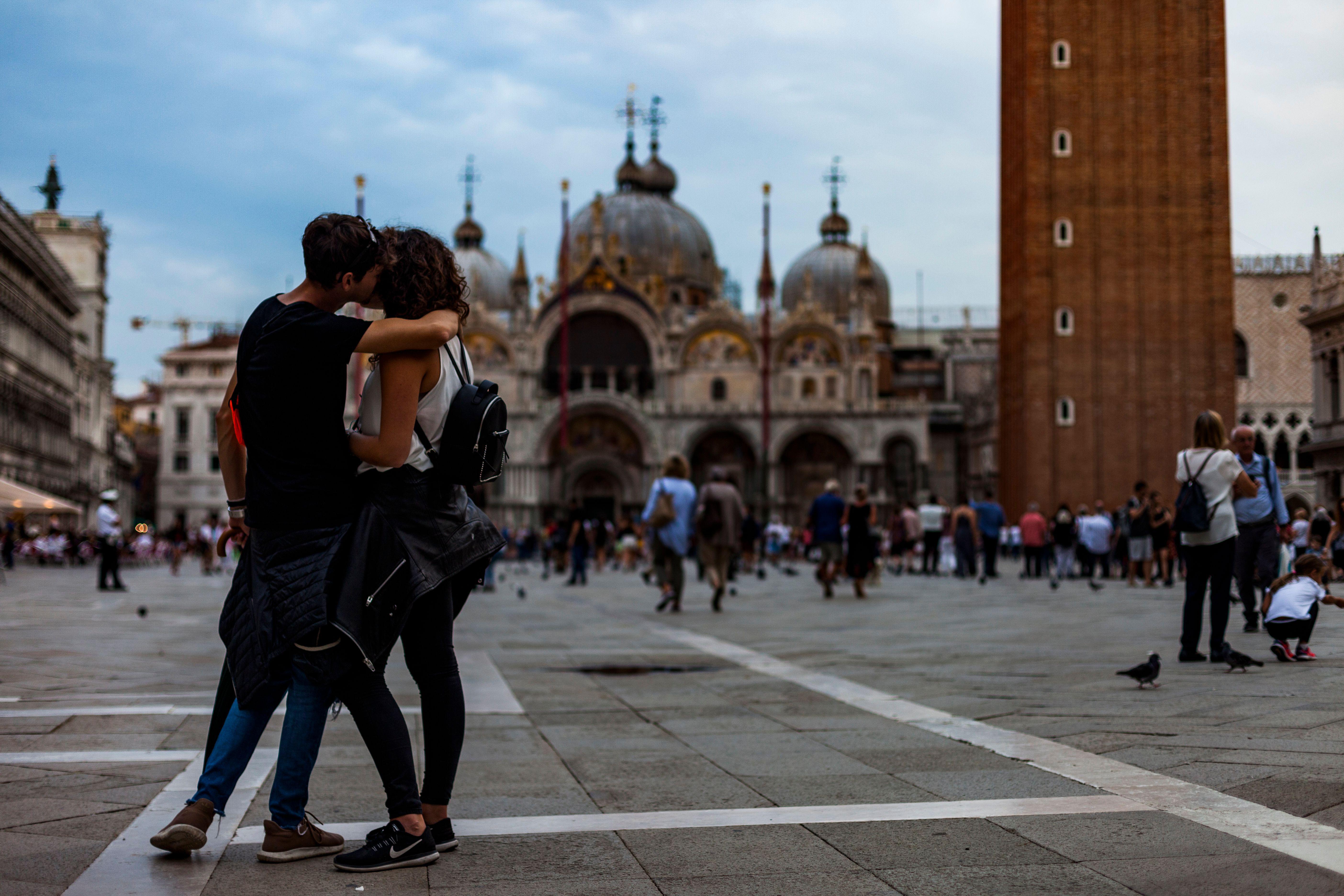 A couple of tourists kiss on St. Mark's Square