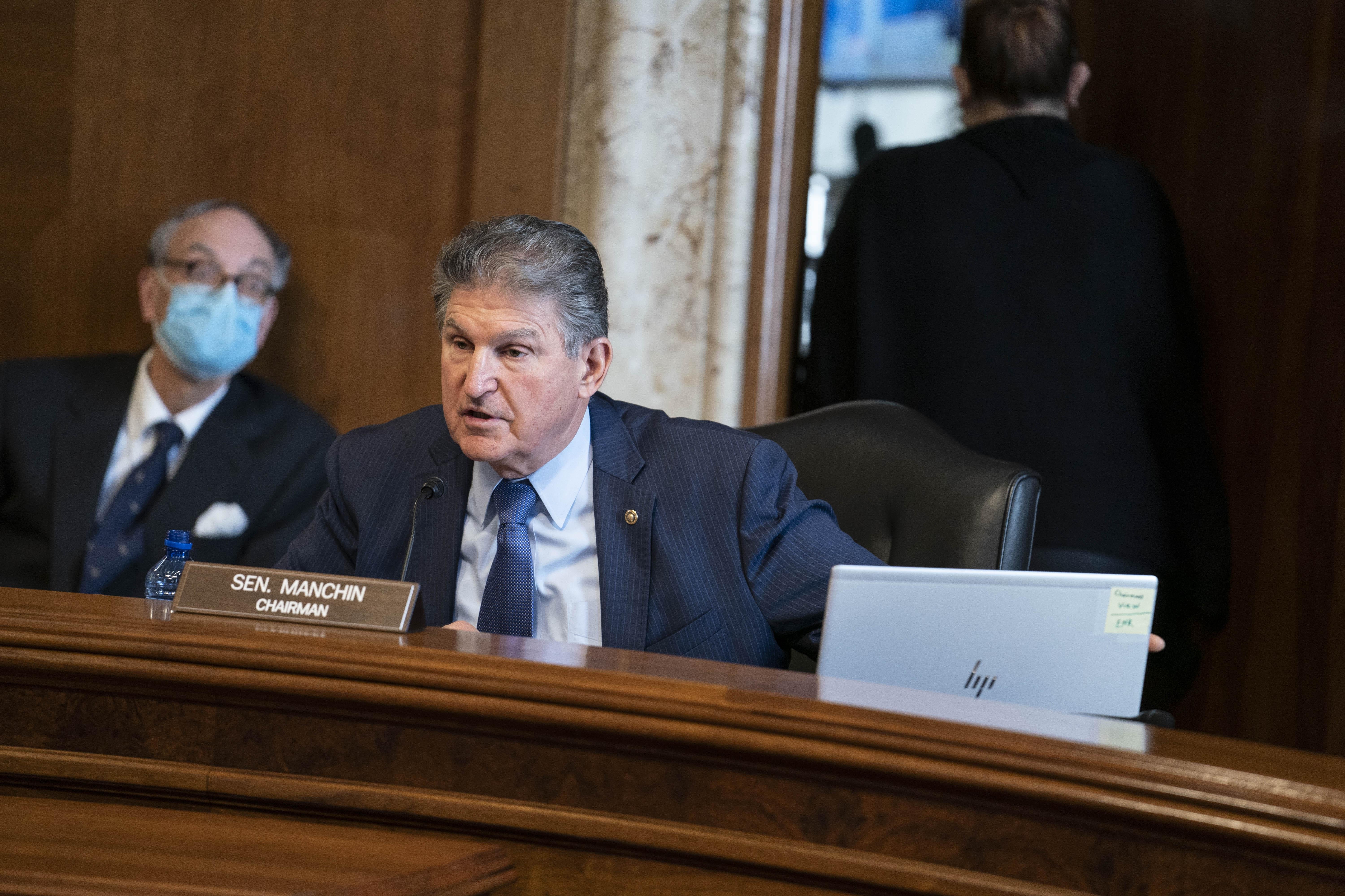 Joe Manchin seated in front of his nameplate