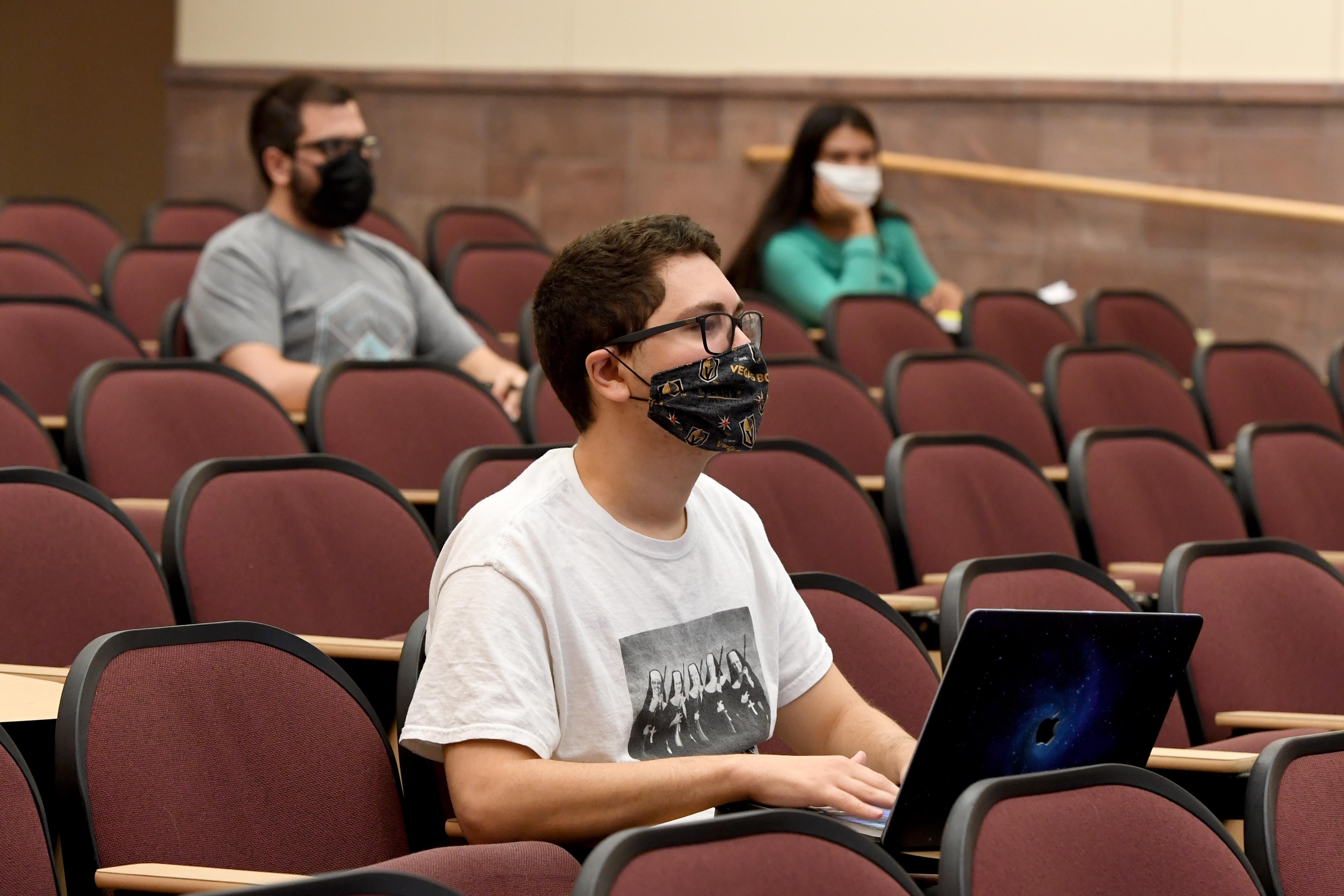 Students wearing masks socially distance in a lecture hall