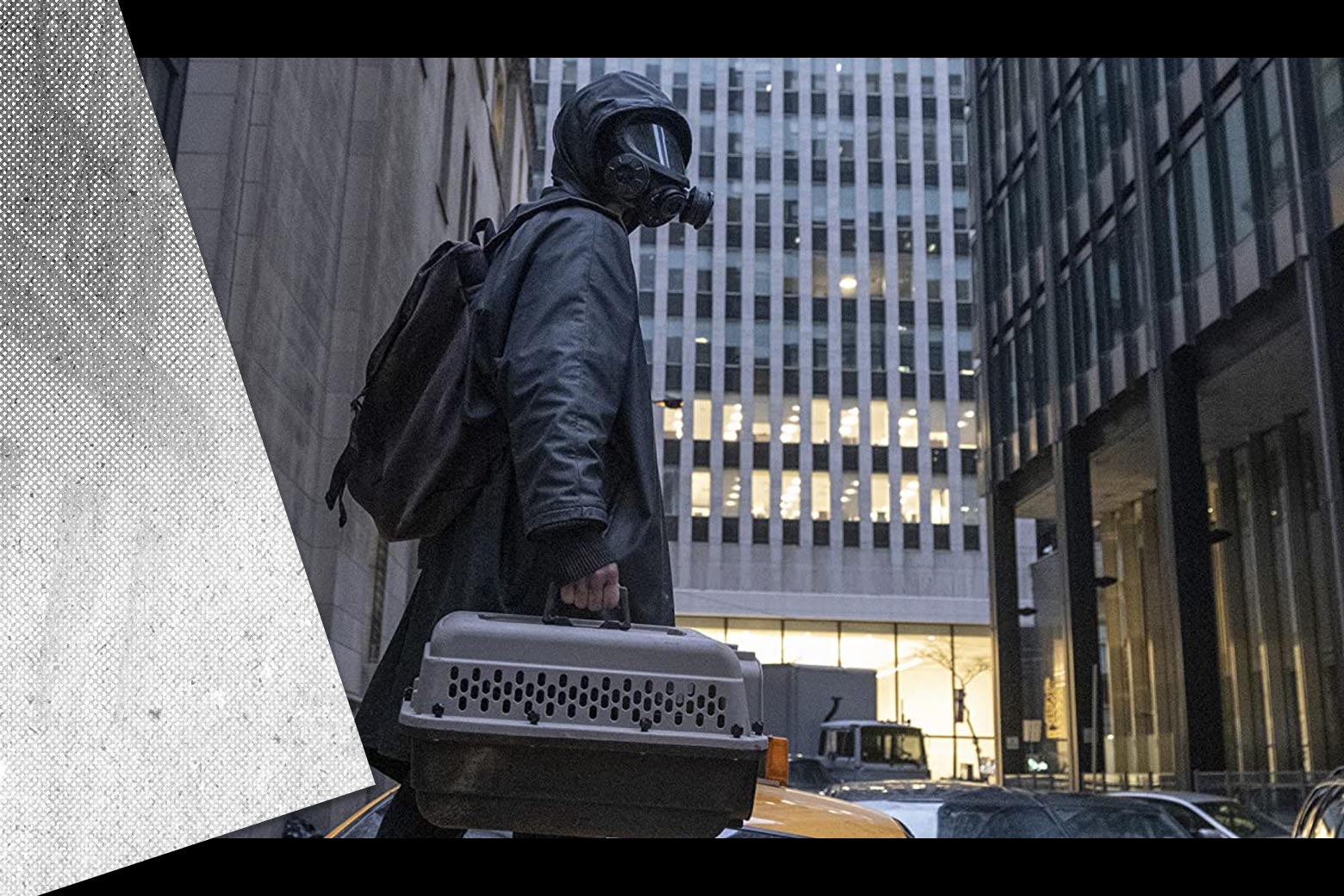 Still from the TV show of Yorick wearing a gas mask and poncho standing in an empty city street, with a black-and-white hand-drawn comic panel overlaid on the side of a skyscraper in the background