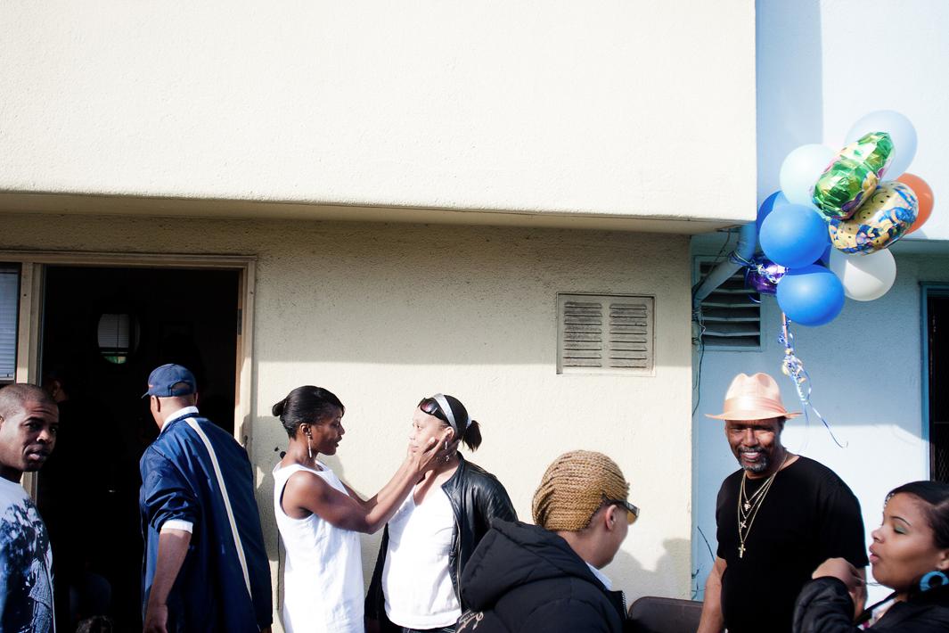 Women embrace at the Branner family reunion on Harbor Row in Hunters Point.