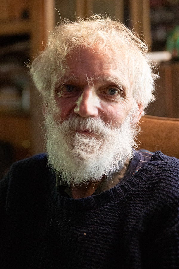 A headshot of author Ken Smith looking older with a thick white beard and scraggly hair.