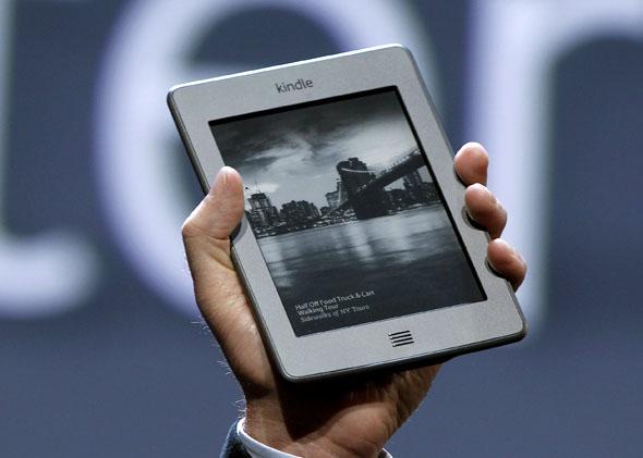 Amazon CEO Jeff Bezos holds up the new Kindle Touch at a news conference during the launch of Amazon's new tablets in New York September 28, 2011. 