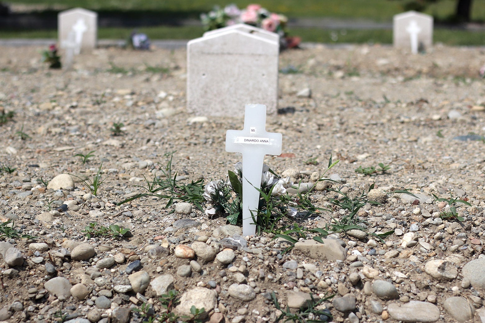 A close-up of a makeshift grave with a cross.