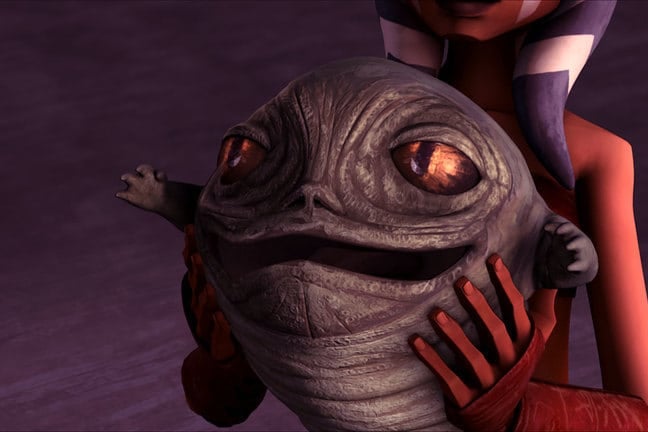 In a 3D-animated style, a pair of orange arms hold a small slug with large eyes and a wide mouth.