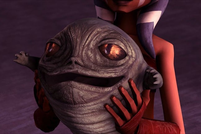 In a 3D-animated style, a pair of orange arms hold a small slug with large eyes and a wide mouth.  