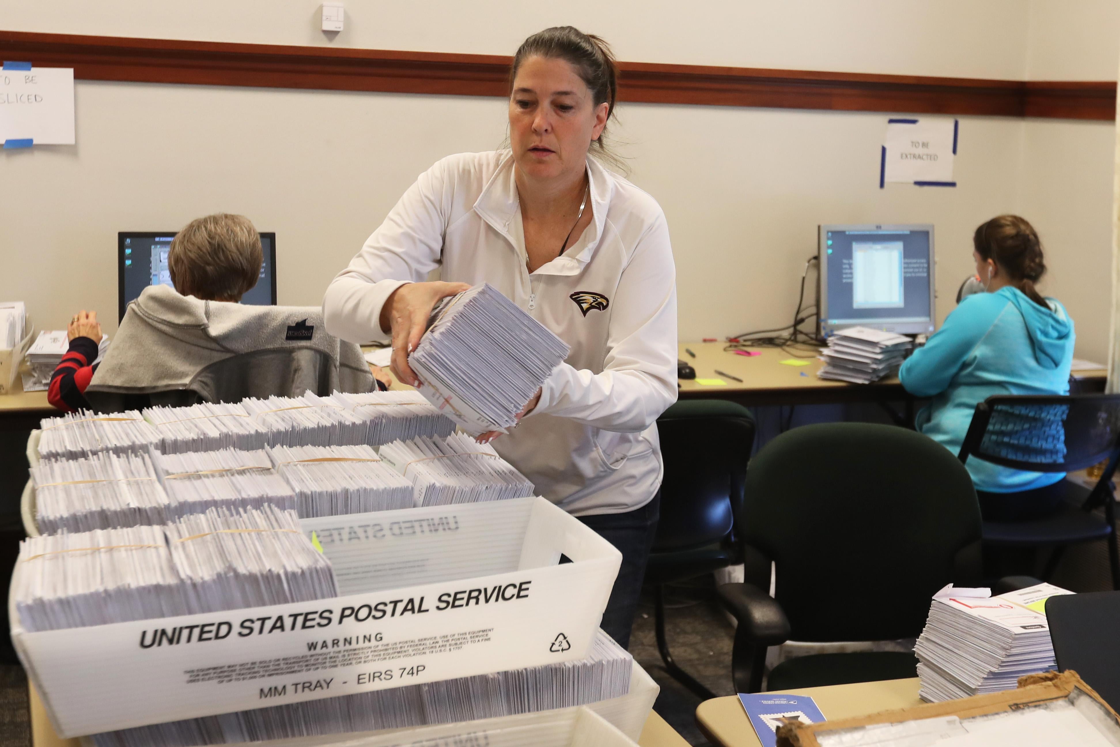 Thousands of ballots sit in boxes as Utah County election workers process the mail-in ballots. Utah conducts elections entirely by mail.