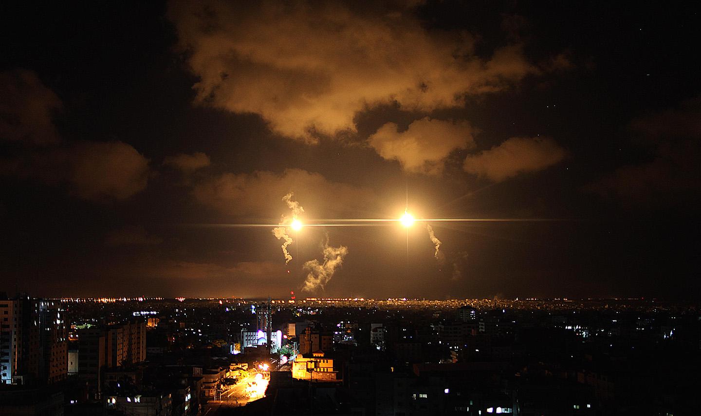 Aircraft flares illuminate the sky following an Israel airstrike over al-Suaciye district of Gaza City.