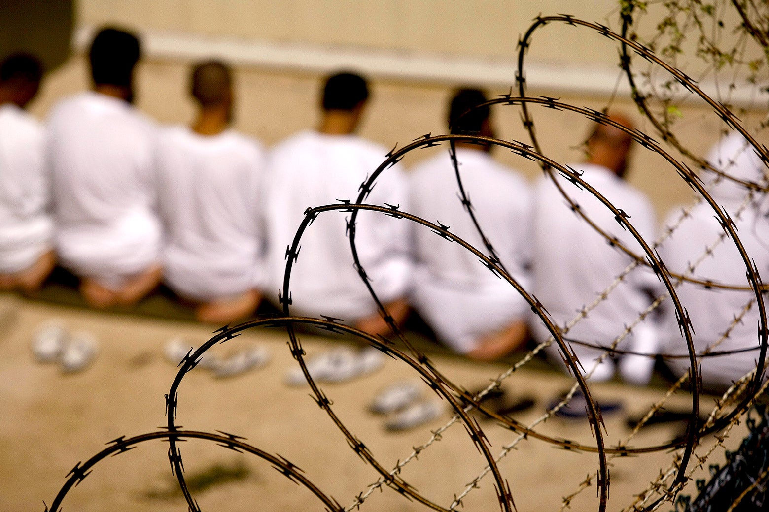 A group of detainees kneels during an early morning Islamic prayer in their camp in Guantanamo Bay, Cuba. 