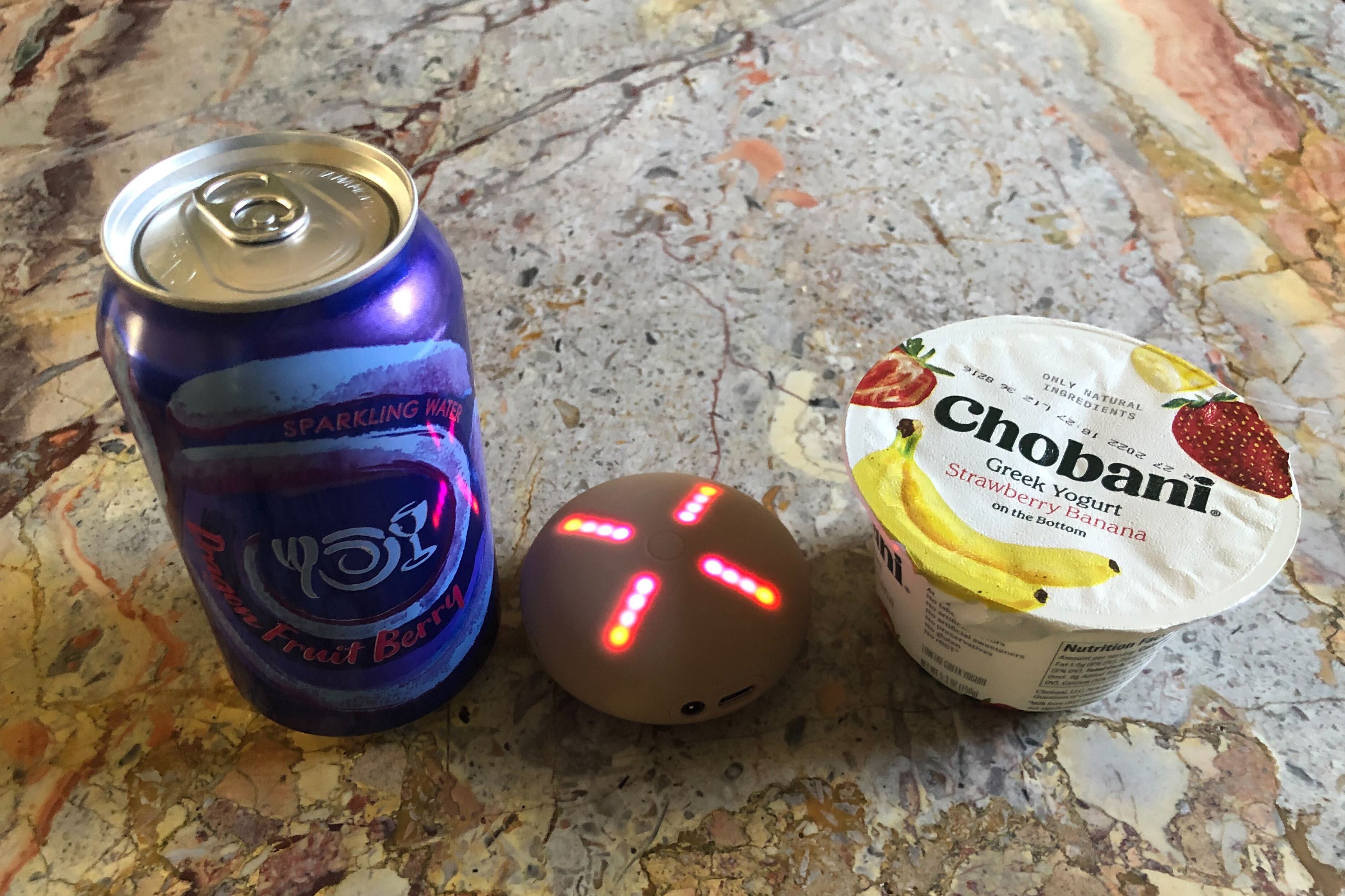 A Stem Player sits between a 12-ounce aluminum can and a 5-ounce yogurt container on a granite countertop