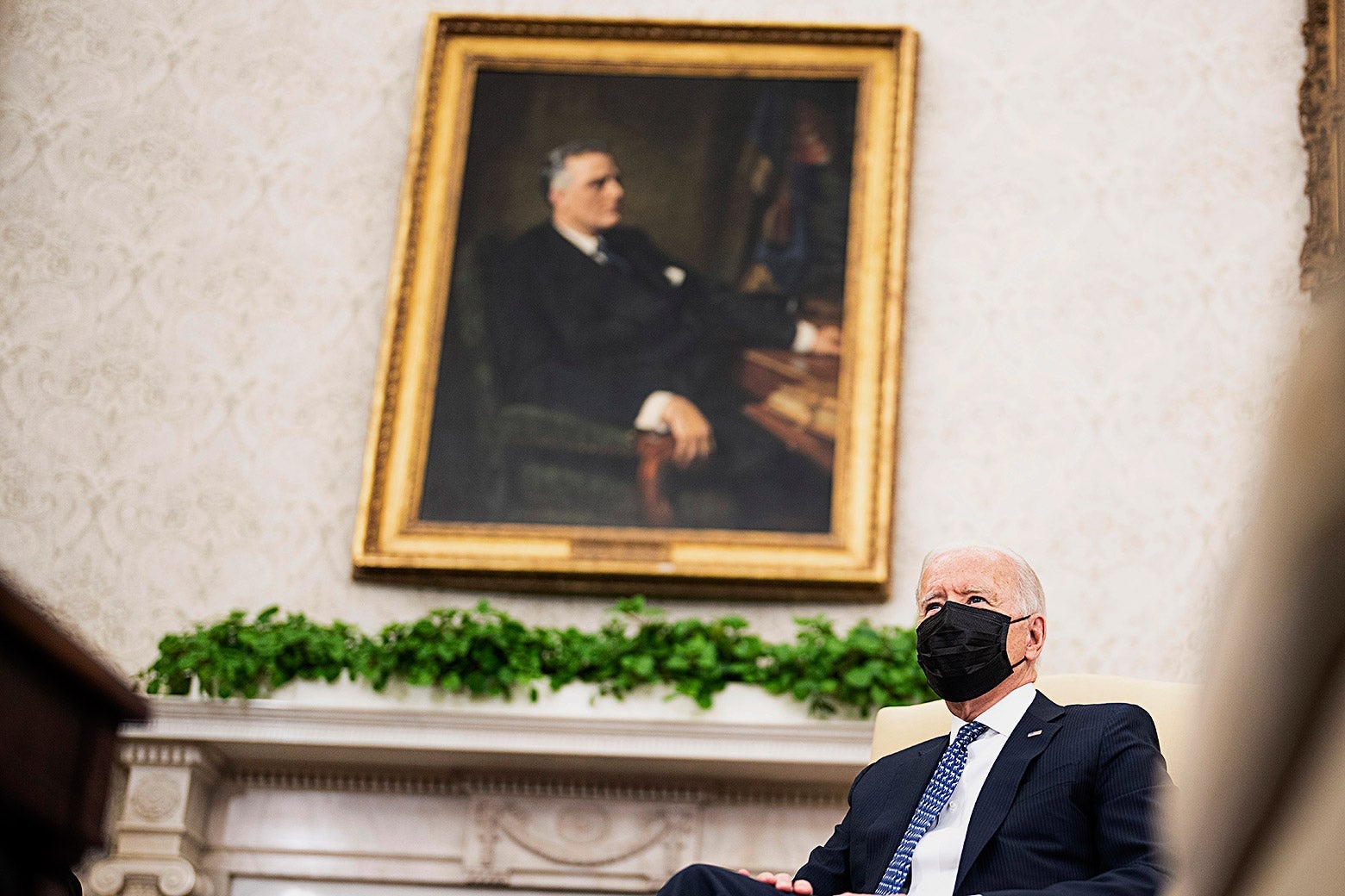  Joe Biden sits underneath a portrait of former President Franklin D. Roosevelt in the Oval Office.