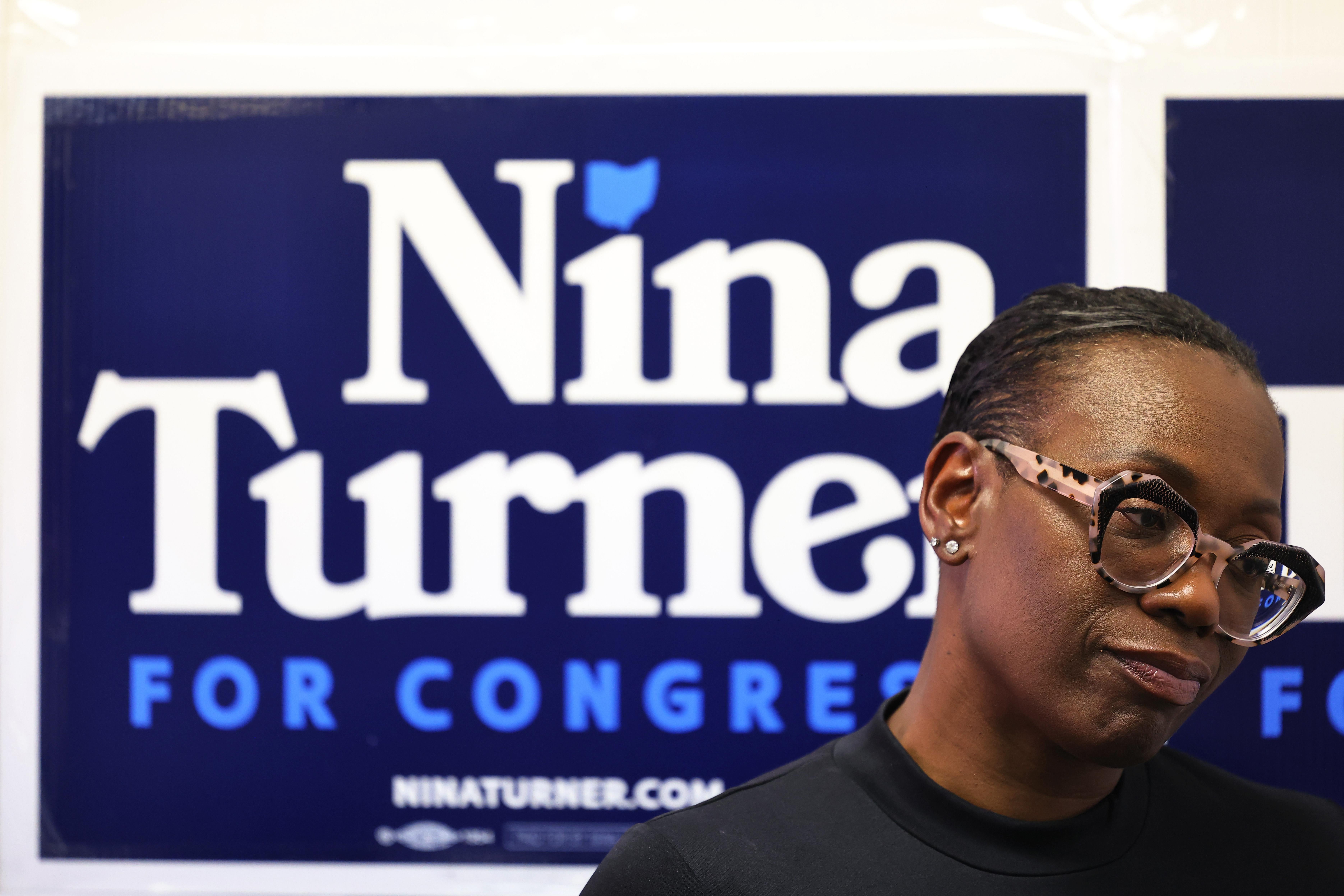 Nina Turner standing in front of a campaign sign.