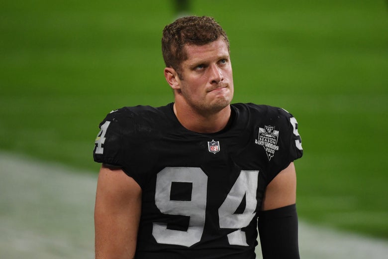 Carl Nassib frowns while standing on a football field in a Las Vegas Raiders jersey.