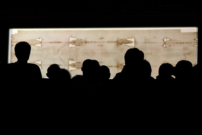 Heads silhouetted black with the shroud behind them.