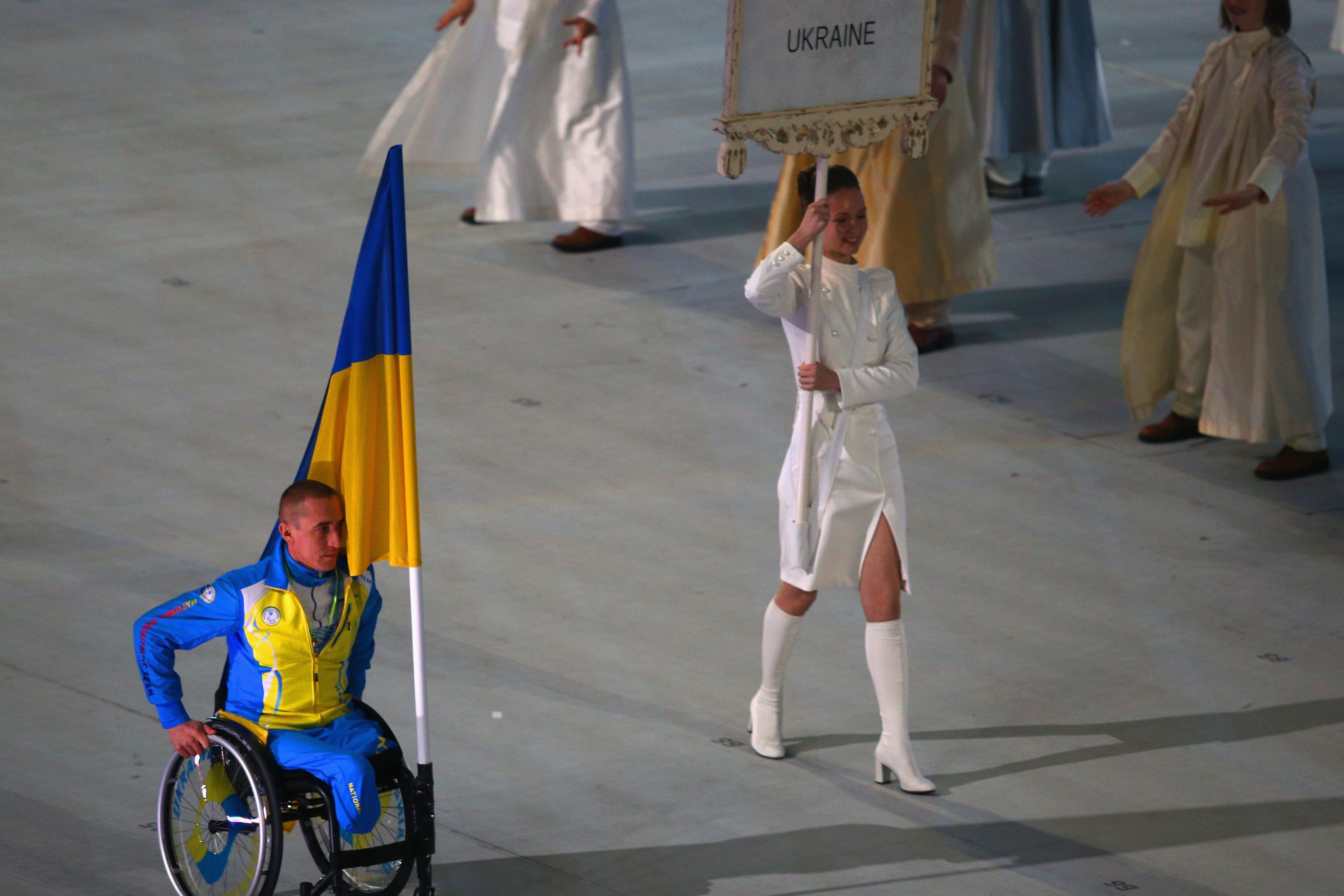 Mykailo Tkachenko of Ukraine bears the flag during the opening ceremony of the Sochi 2014 Paralympic Winter Games at Fisht Olympic Stadium.