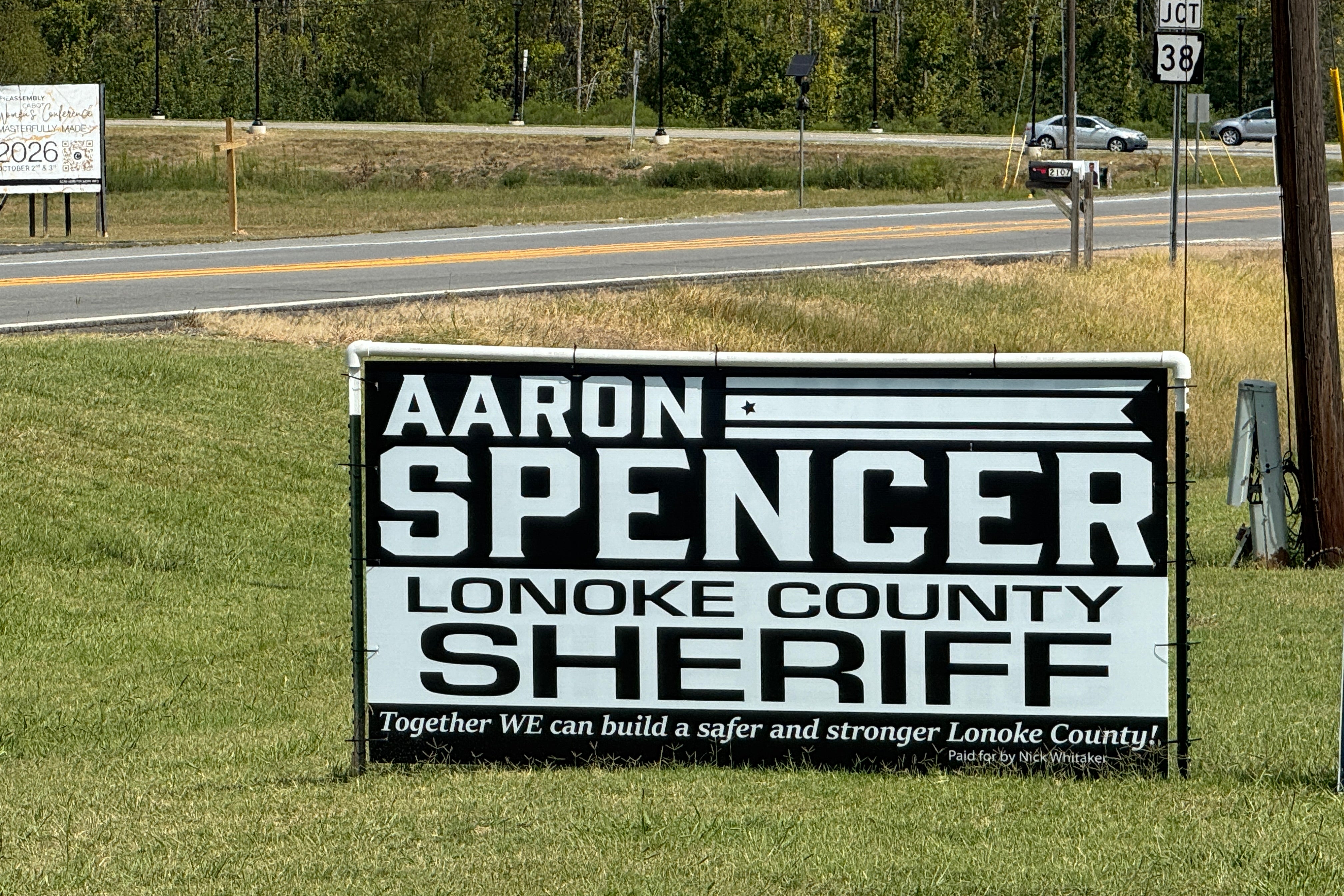 A black and white sign says Aaron Spencer for Sheriff. 